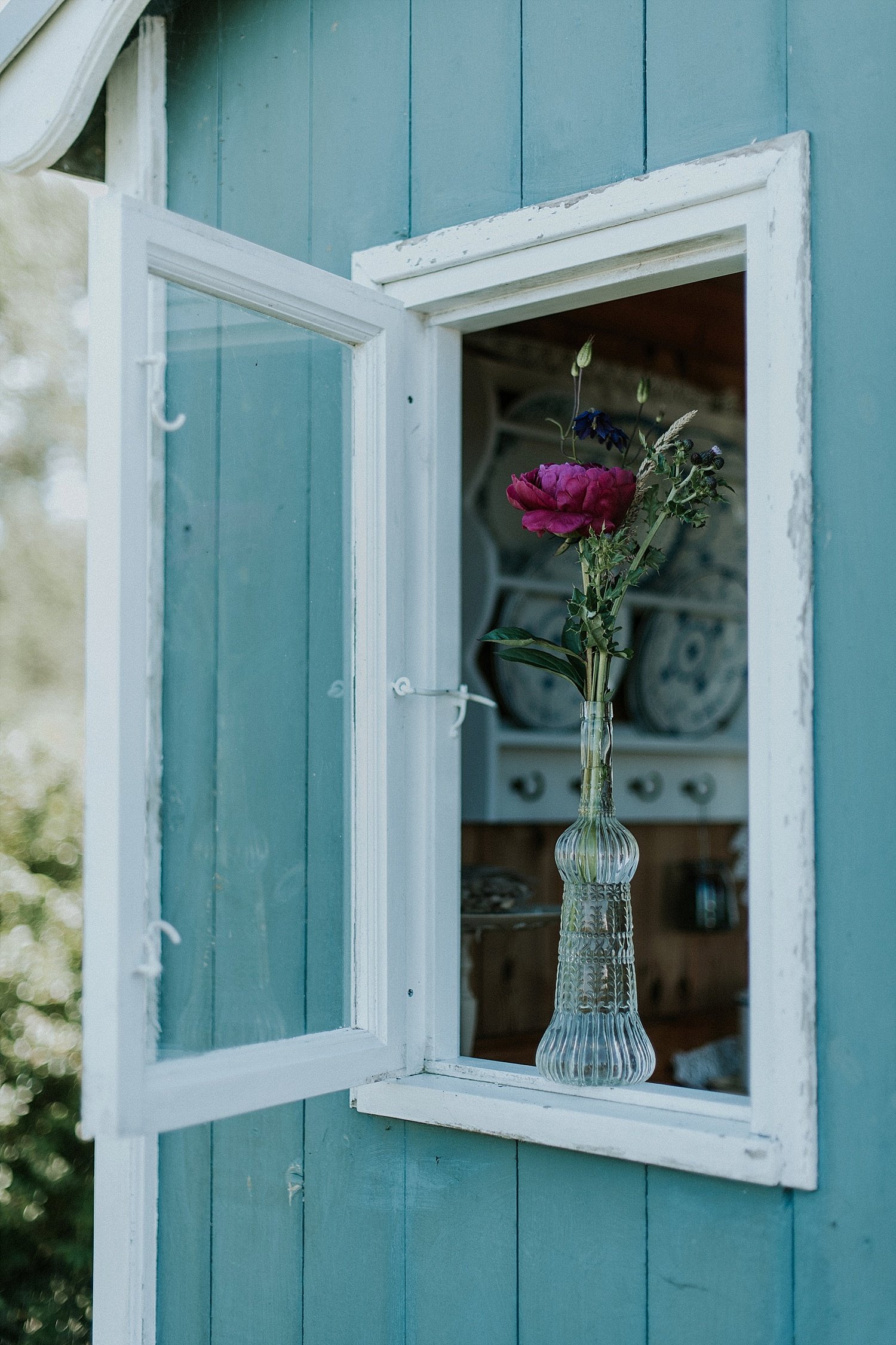 long stemmed flowers in crystal glass vase on window ledge  |  Aero Island | Danish Island Weddings | Full service Denmark wedding planners