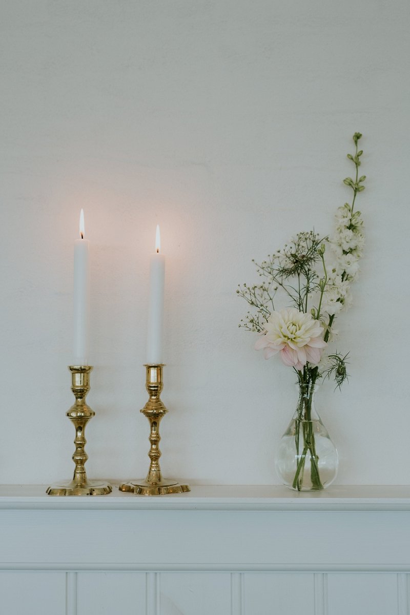 floral bouquet on mantel with two candles and gold candlesticks | Aero Island | Danish Island Weddings | Full service Denmark wedding planners