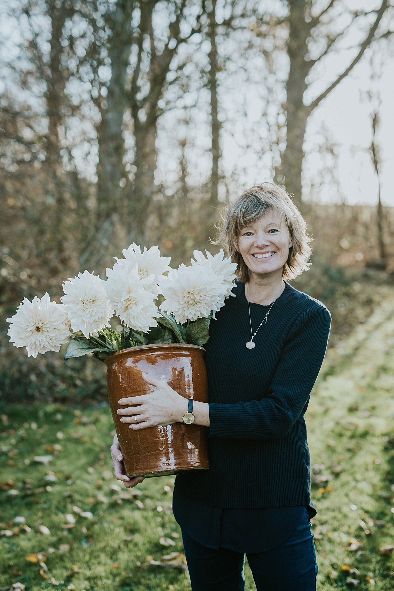 woman holding large white long stemmed flowers  | elope abroad | Aero Island | Danish Island Weddings | Full service Denmark wedding planners 