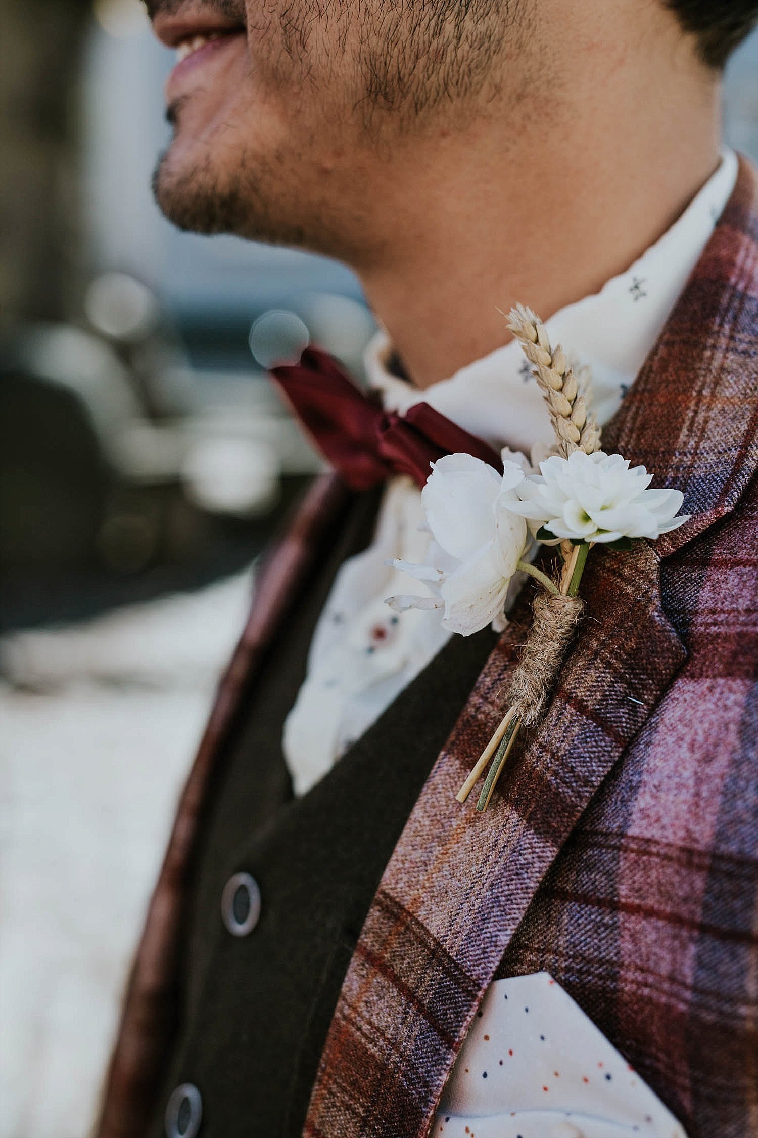 groom in plaid jacket with simple boutonniere
