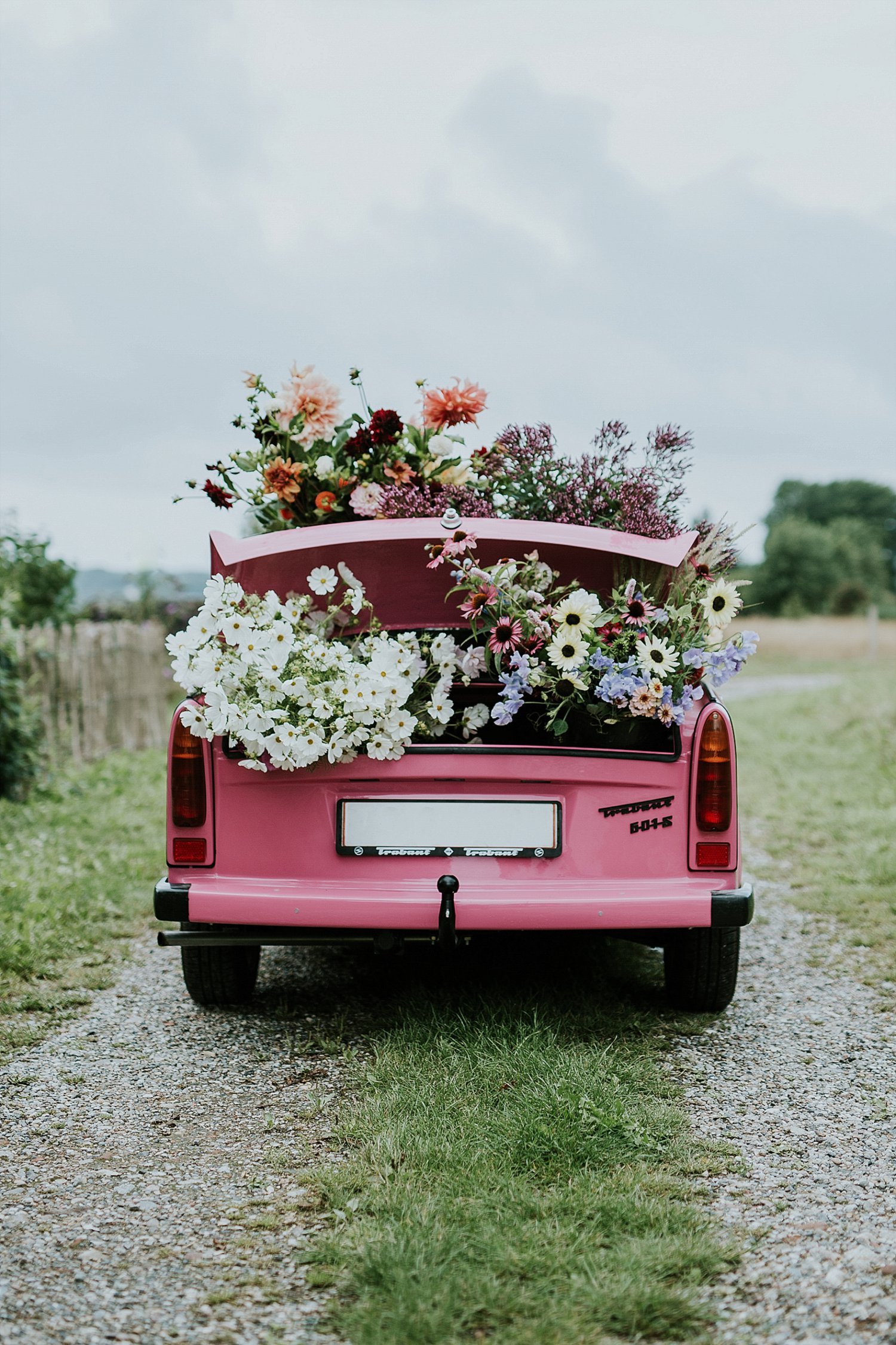 pink car with fresh flowers on top and in trunk | Get married abroad | Danish Island Weddings | Full service Denmark wedding planners