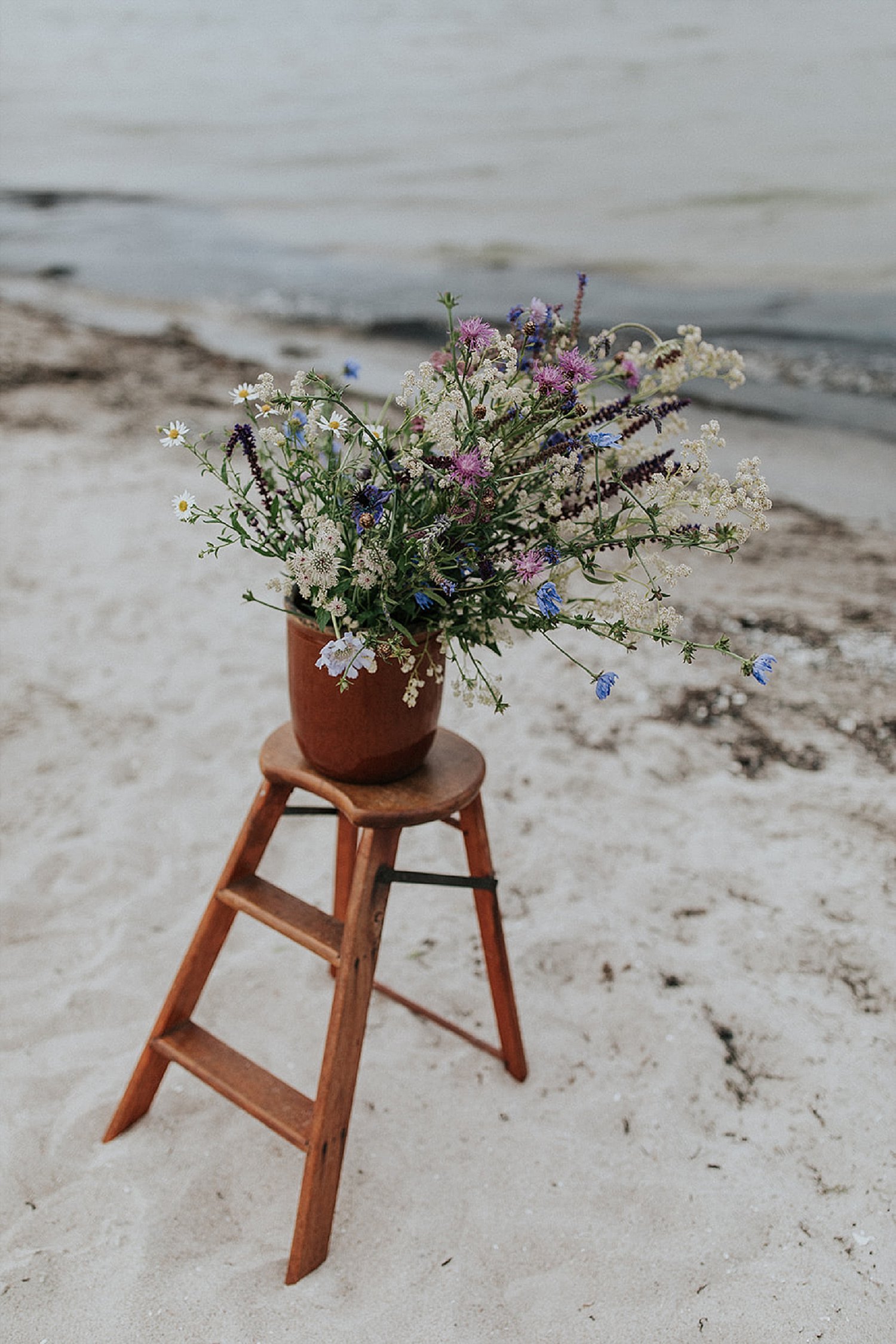 whimsical flowers in bucket on step stool | beach wedding | | Aero Island | Danish Island Weddings | Full service Denmark wedding planners