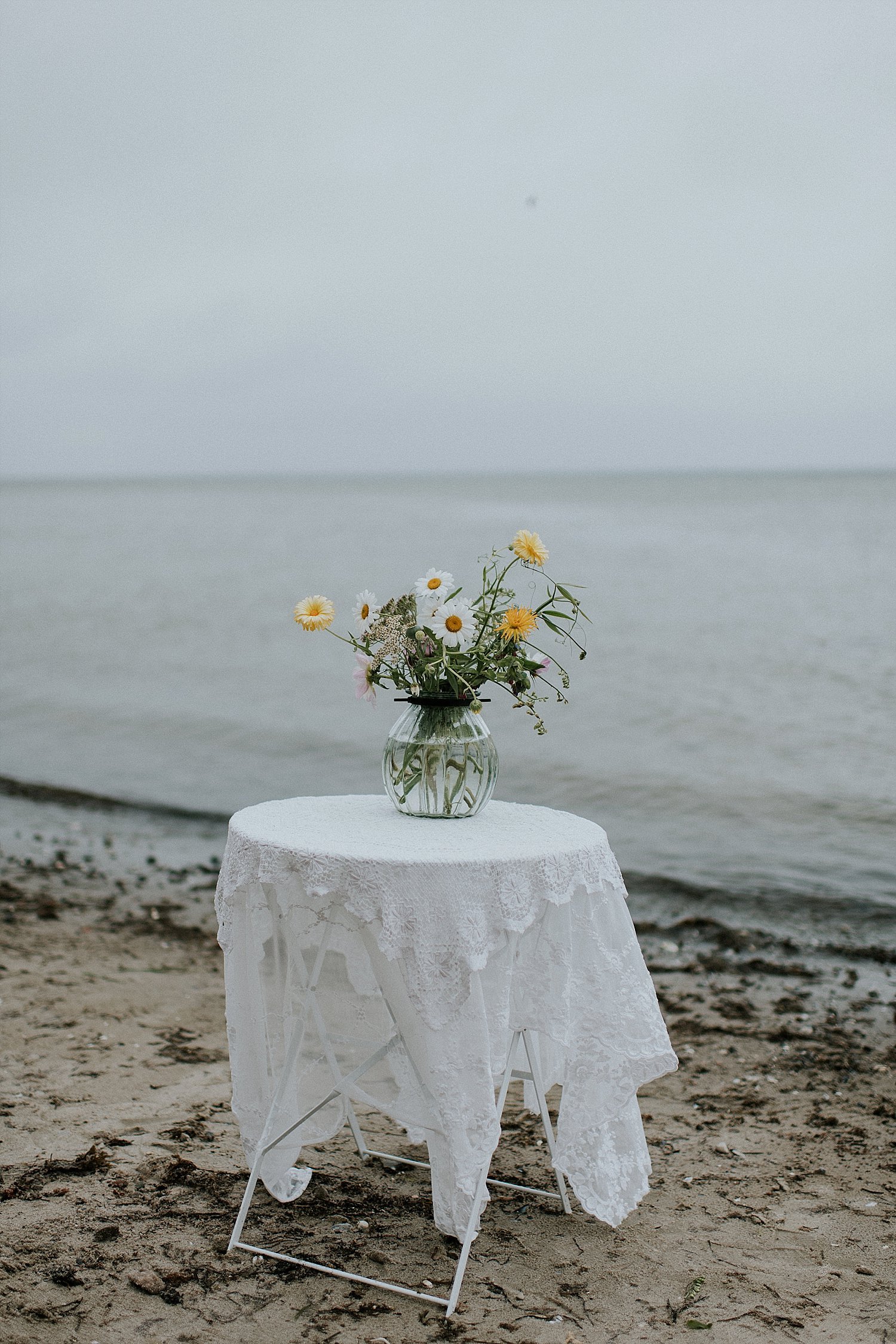 flowers in glass vase on table with white linens | summer beach wedding | Aero Island | Danish Island Weddings | Full service Denmark wedding planners