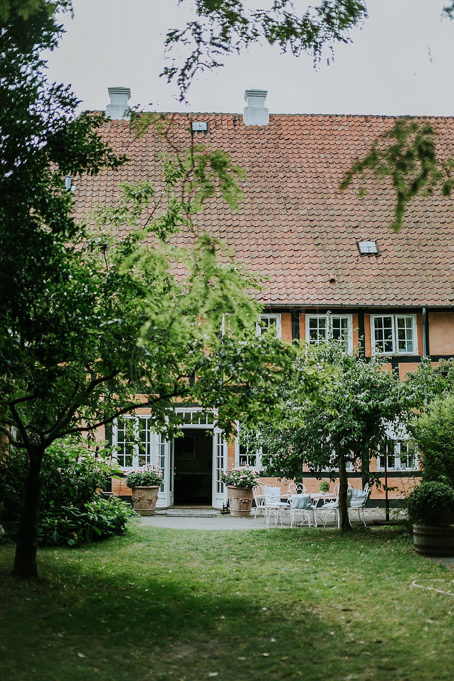 Traditional half timbered house and beautiful garden at Pension Vestergade 44 in Aeroskobing set up for afternoon tea.