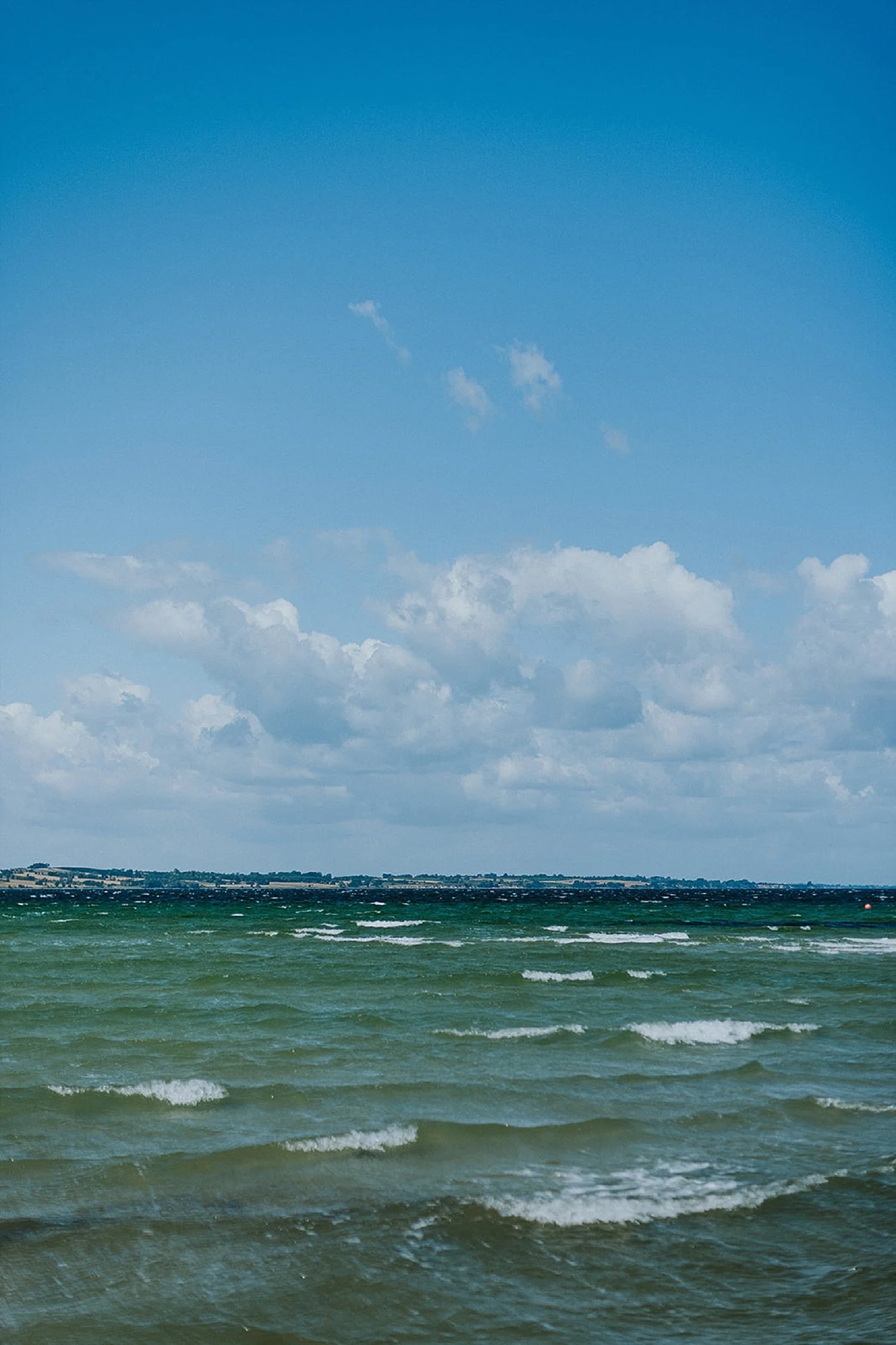 A scenic view of the blue waves in the South Funen Archipelago during a ferry crossing to Aeroe Island.