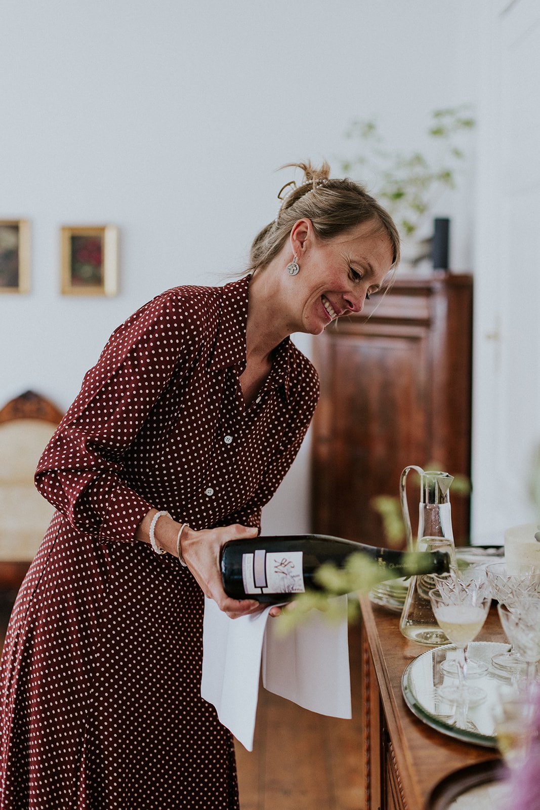 Yuki Badino, wedding planner and sister of founder Louise, pouring premium champagne for a bride and groom, showcasing her expert role in creating a calm, safe, and stress-free wedding planning journey for international couples on Aeroe island.