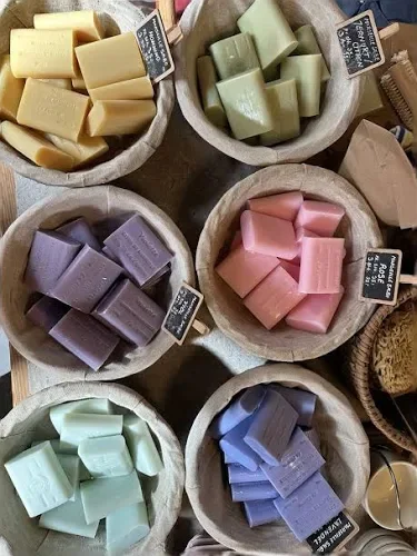 Colorful handmade natural soap bars in woven baskets at the Aeroe Soap Company farm shop. A local artisan craft experience for couples visiting Aeroe Island in Denmark.
