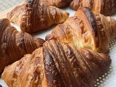 Freshly baked croissants on a cooling rack at Franz Broed micro-bakery in Aeroeskoebing. Ideal inspiration for an elopement picnic on Aeroe Island in Denmark.