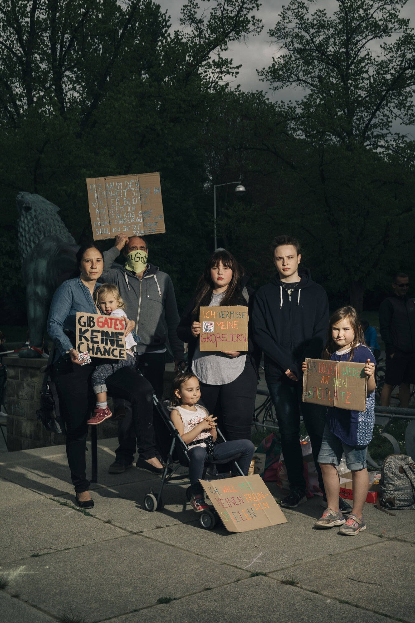  A family poses for a portrait during a demonstration of conspiracy believers. The family believes that the Corona crisis is a conspiracy initiated by Bill Gates. 