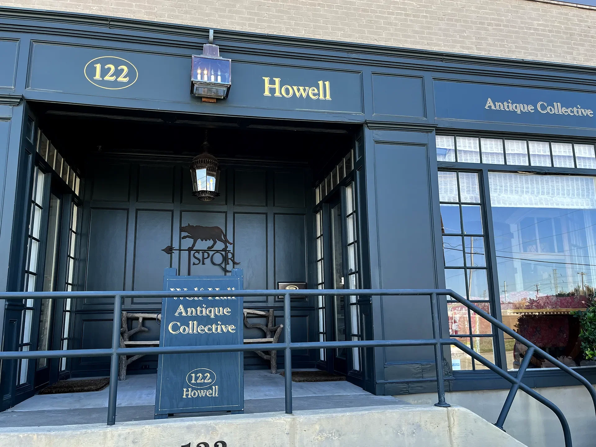 Facade of Howell Antique Collective store at 122 Howell with a blue exterior, a signboard, and a wolf silhouette logo.