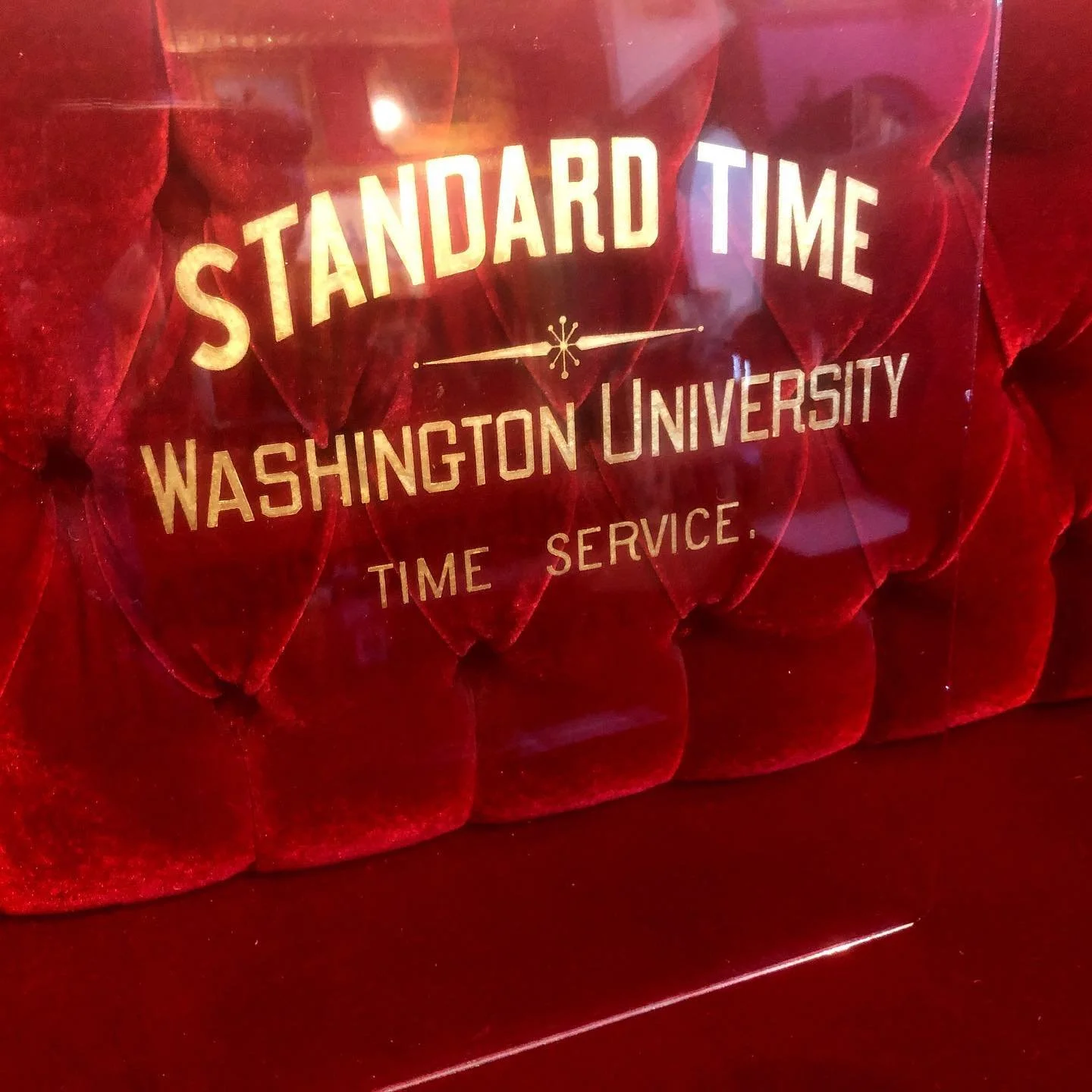 Red velvet tufted background with gold text that reads 'Standard Time Washington University Time Service'.