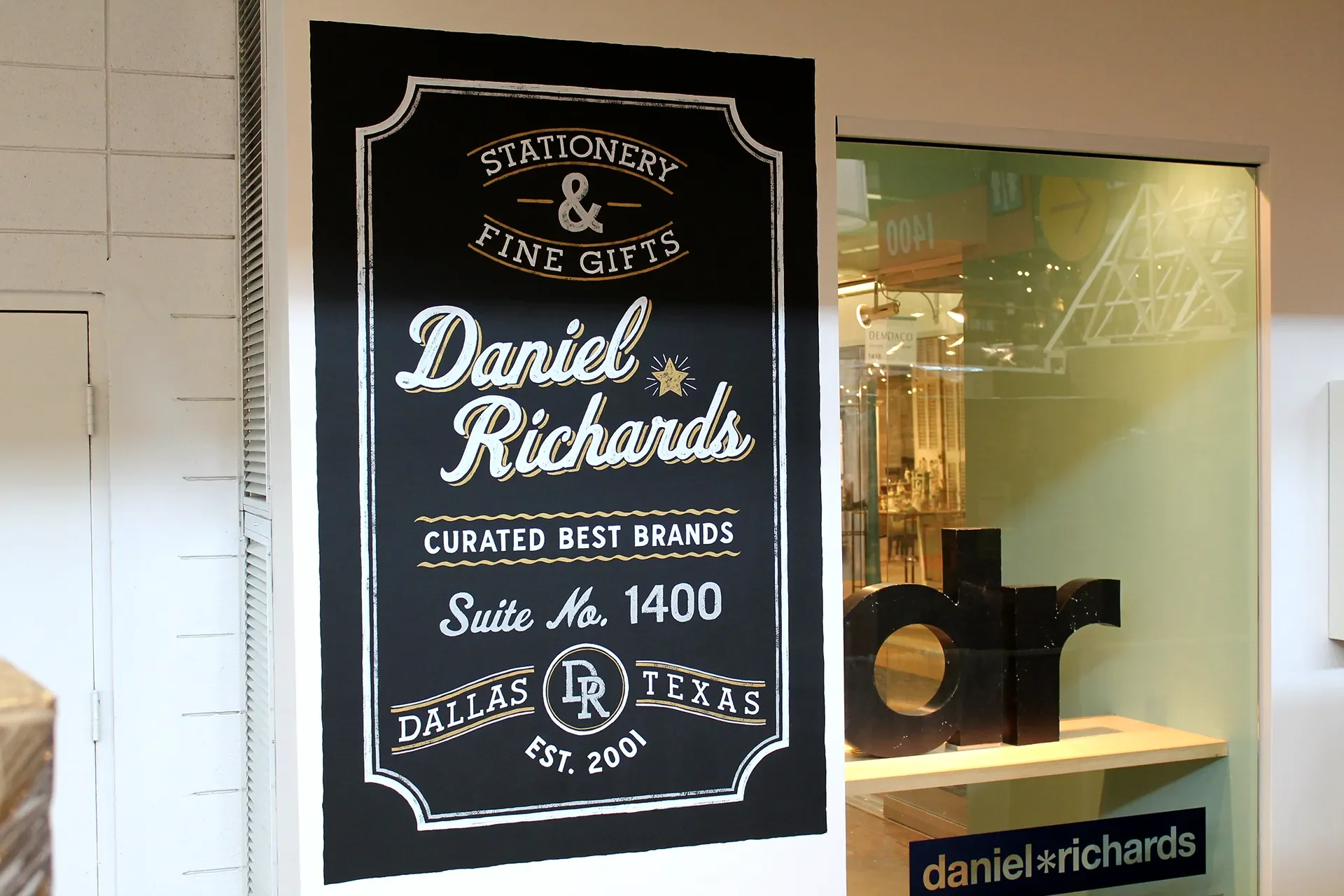 Black and white storefront sign for Daniel Richards, stationery and fine gifts store, located in Dallas, Texas, established in 2001, Suite No. 1400.