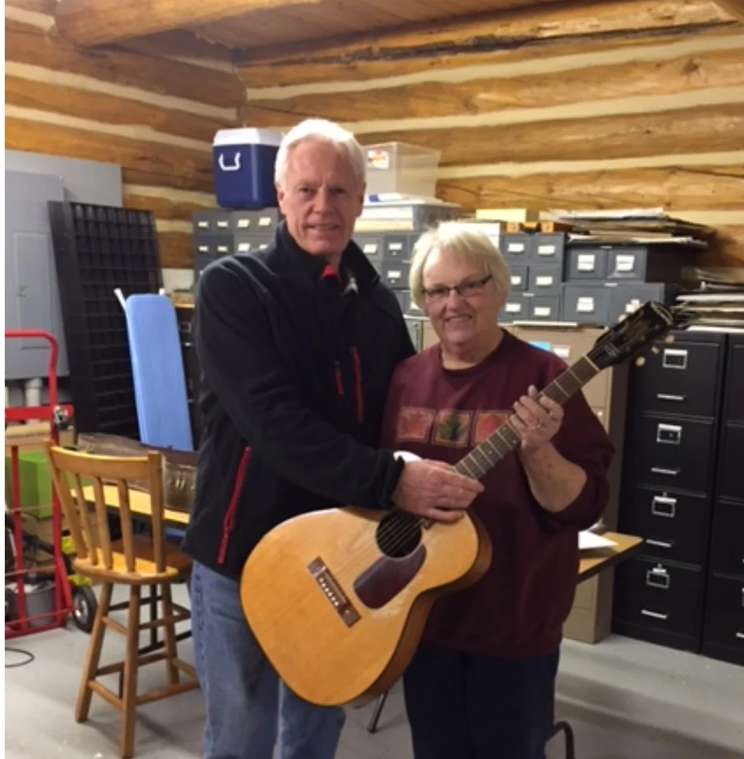 Handing off the Ted Mack audition guitar to Solveig at the Norman County Historical Society in Ada, Minnesota.