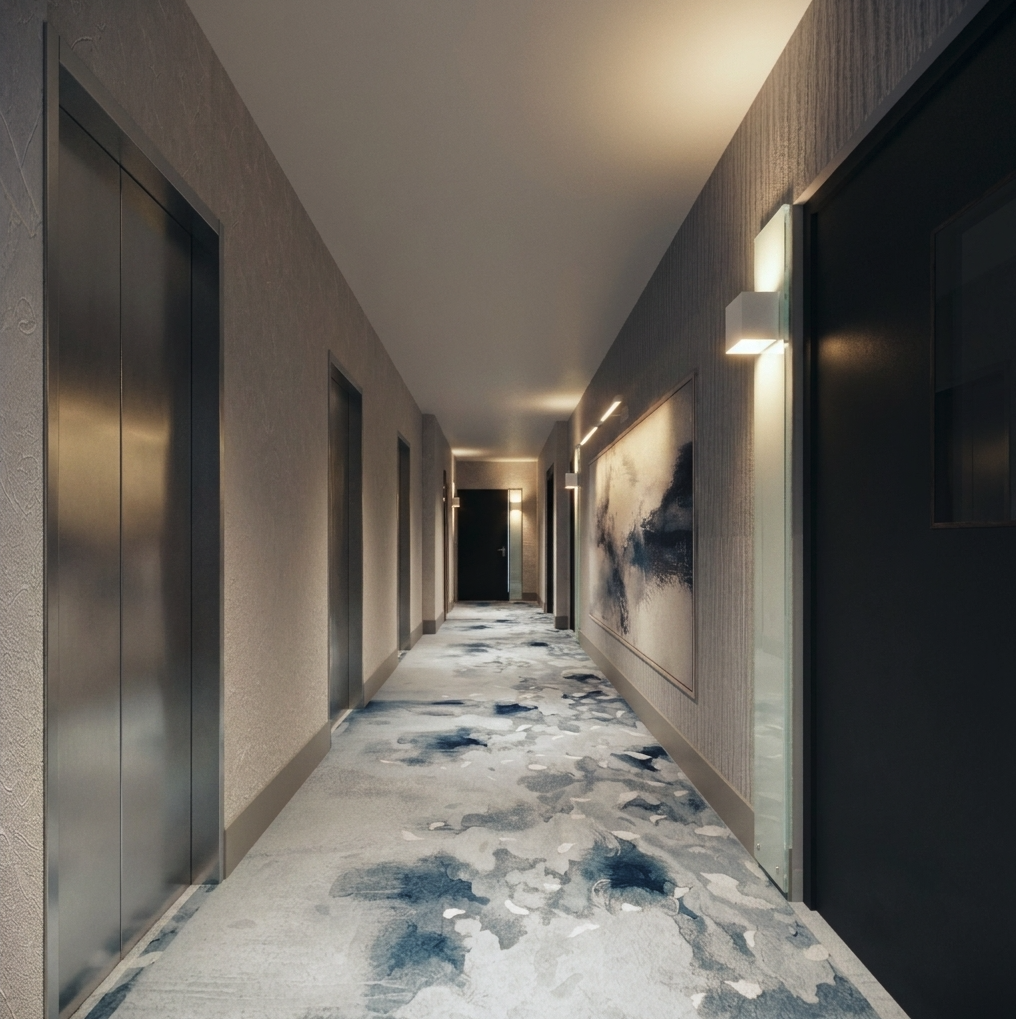 Renovated residential condominium corridor with elevator landing, patterned carpet, and wall art, designed by KAID Design