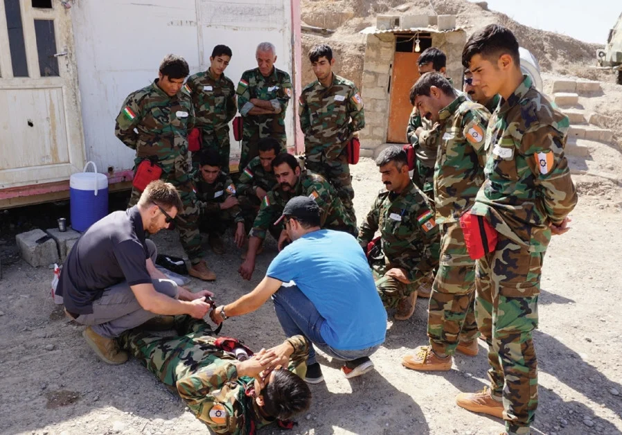 AN FAI VOLUNTEER shows Peshmerga how to apply a tourniquet at a base at Hawija, Iraq. (Photo credit:SETH J. FRANTZMAN)