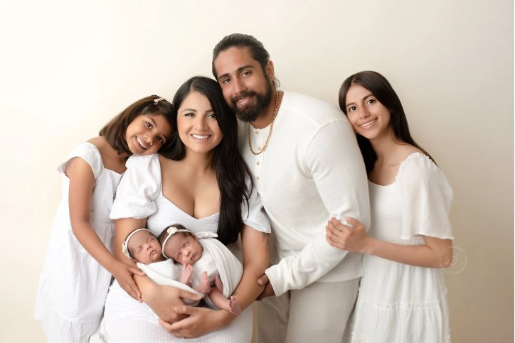 Newborn family photography in Modesto, CA featuring a sweet moment between a newborn baby and their older sibling in a professional studio
