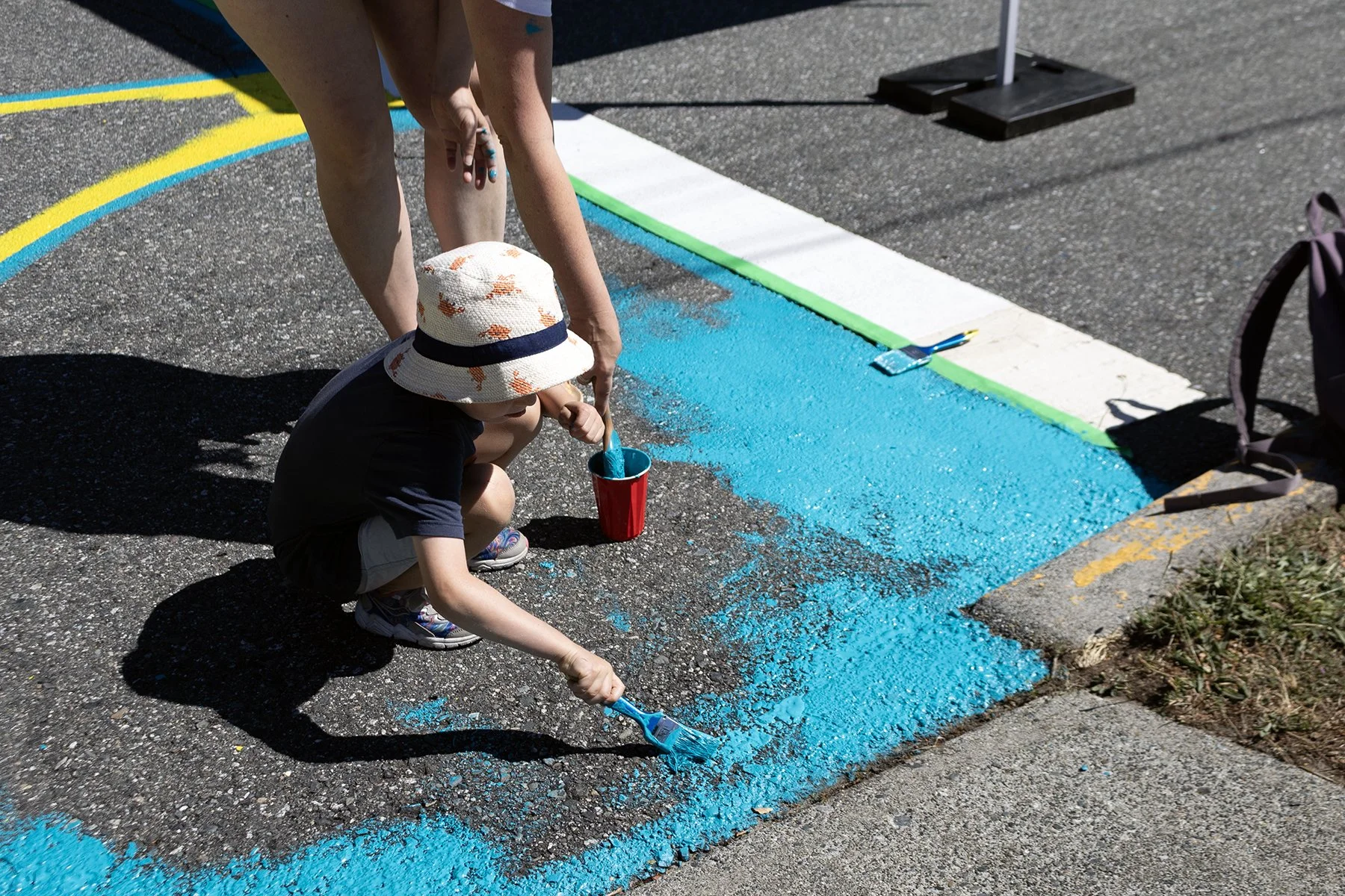 Another child helps paint the mural.