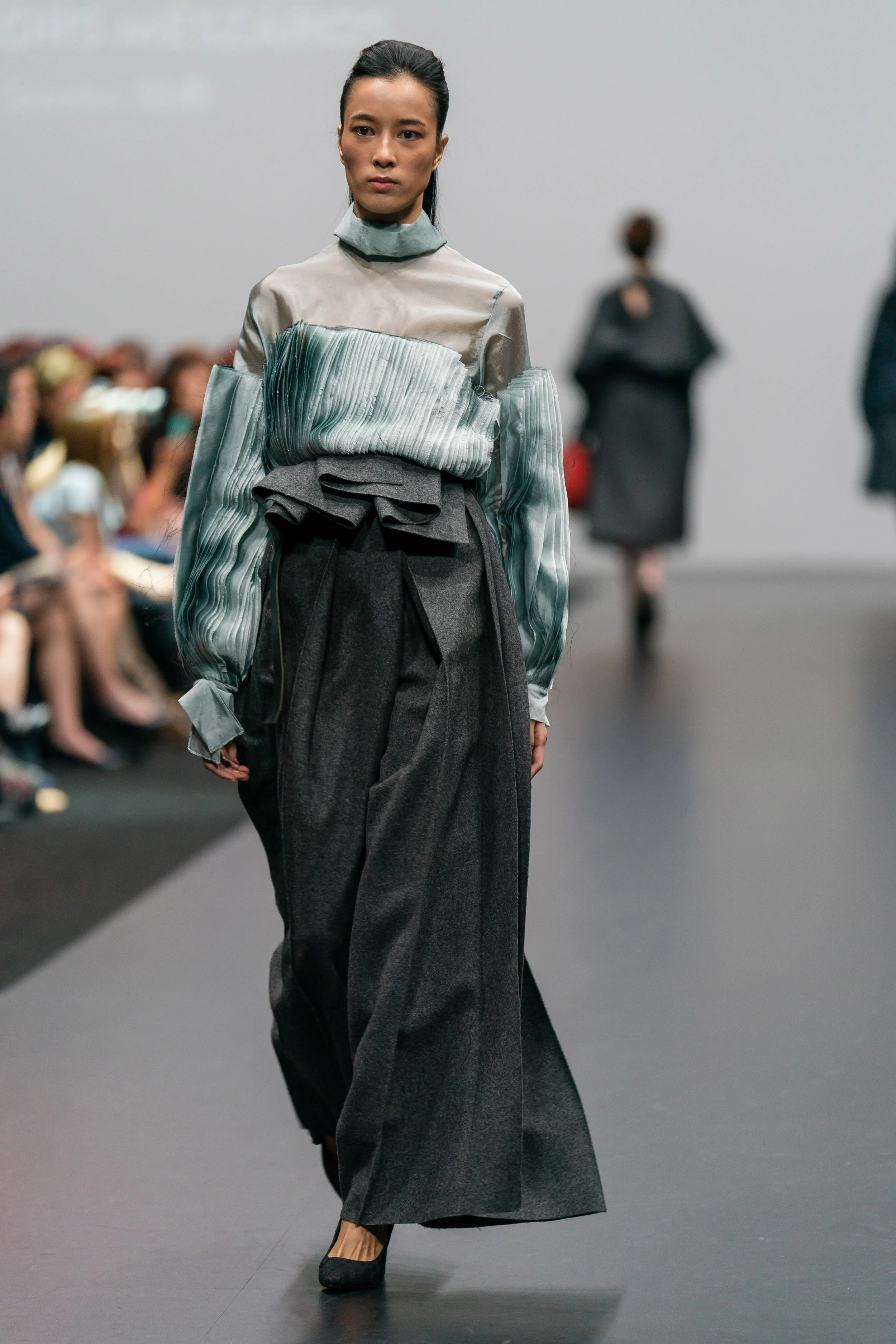 Amanda Borgfors Mészàros Zero-waste pleated teal polyester blouse and zero-waste charcoal grey wool trousers up-cycled from end-of-rolls