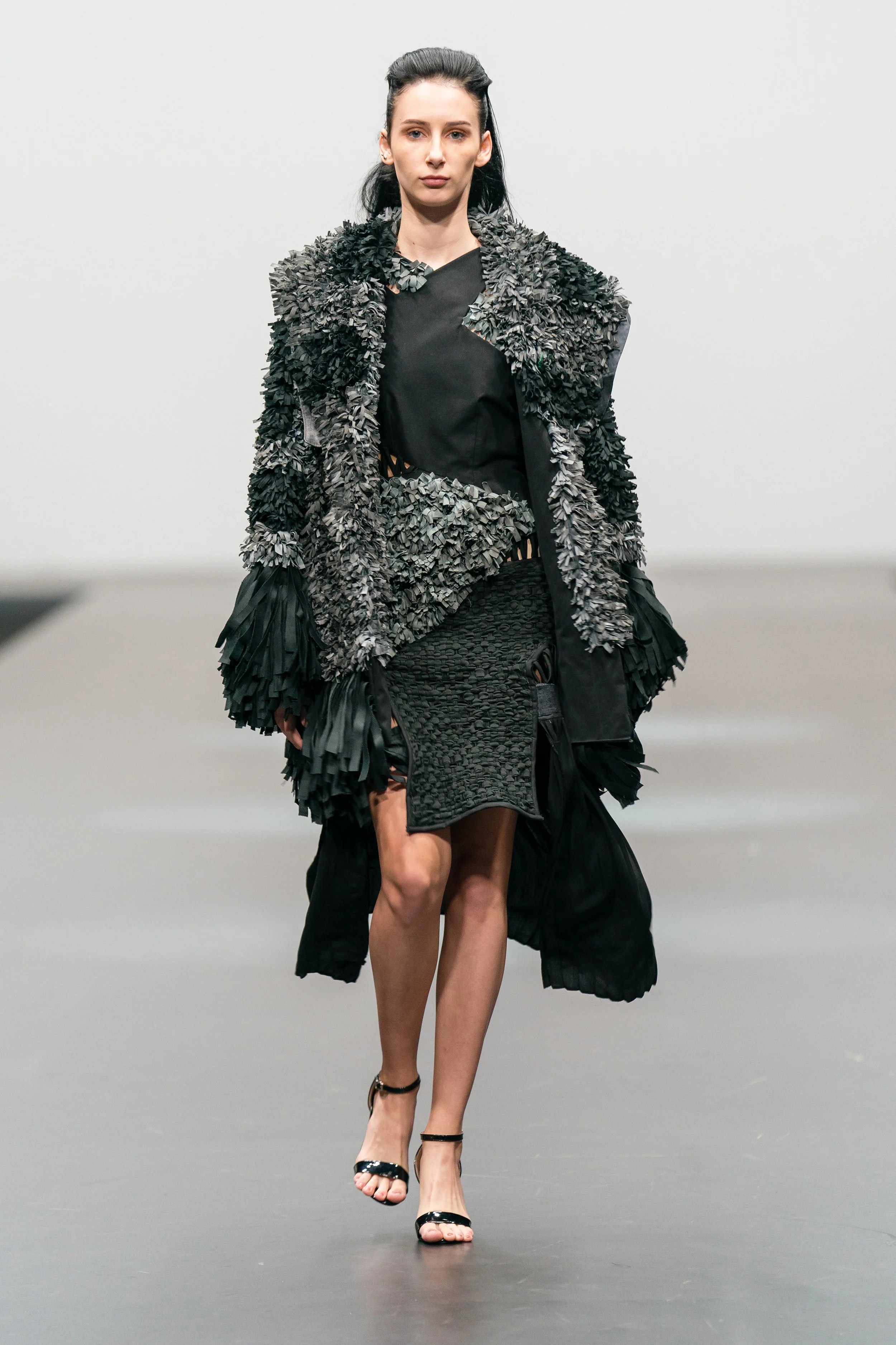 Candle Ray Torreverde Up-cycled and reconstructed monochrome woven textured overcoat, with sleeveless asymmetric dress made from hand clothing and end-of-rolls