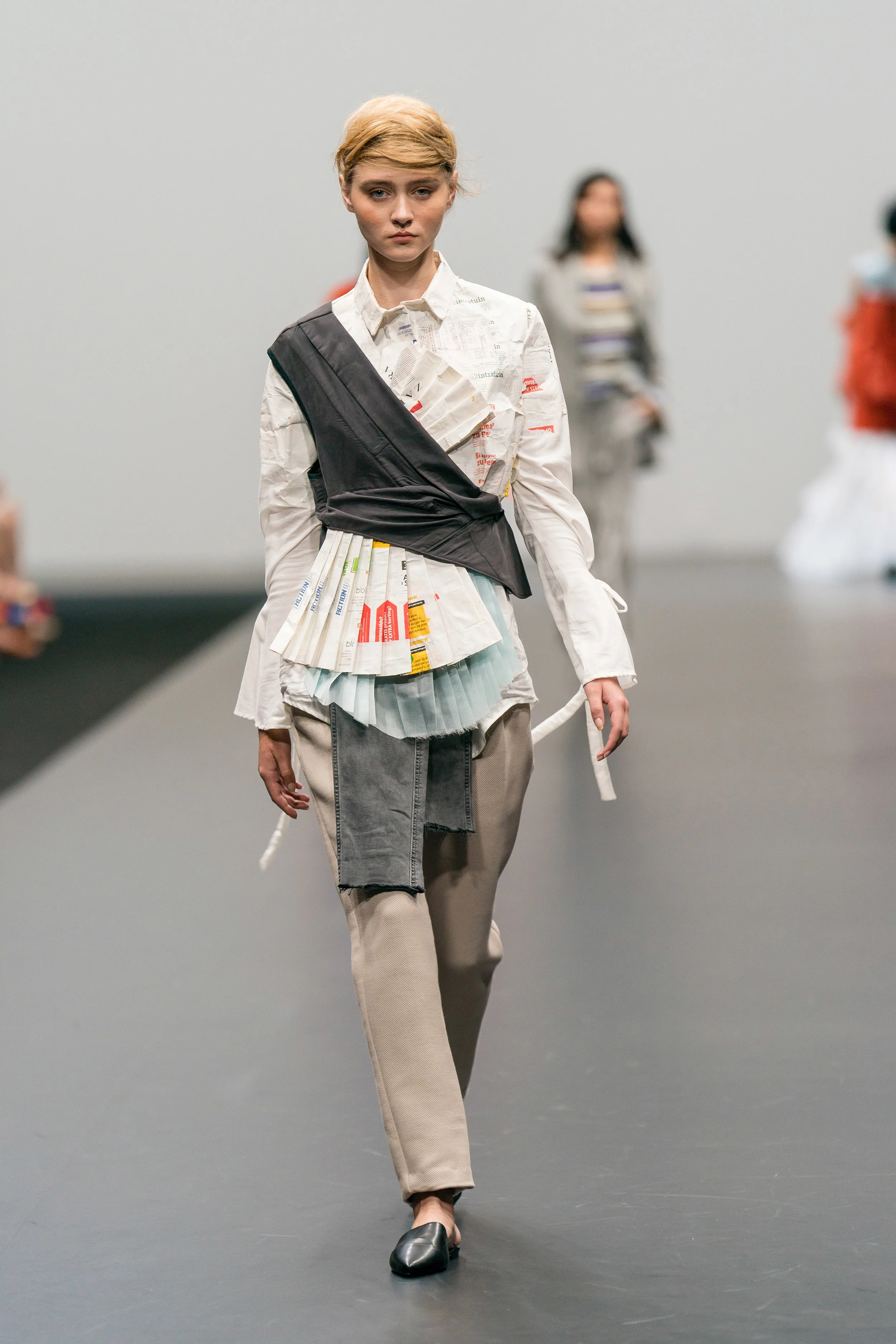 Joëlle van de Pavert Layered up-cycled top and reconstructed tailored camel trousers, made from secondhand clothing and textile swatches, embellished with paper receipts