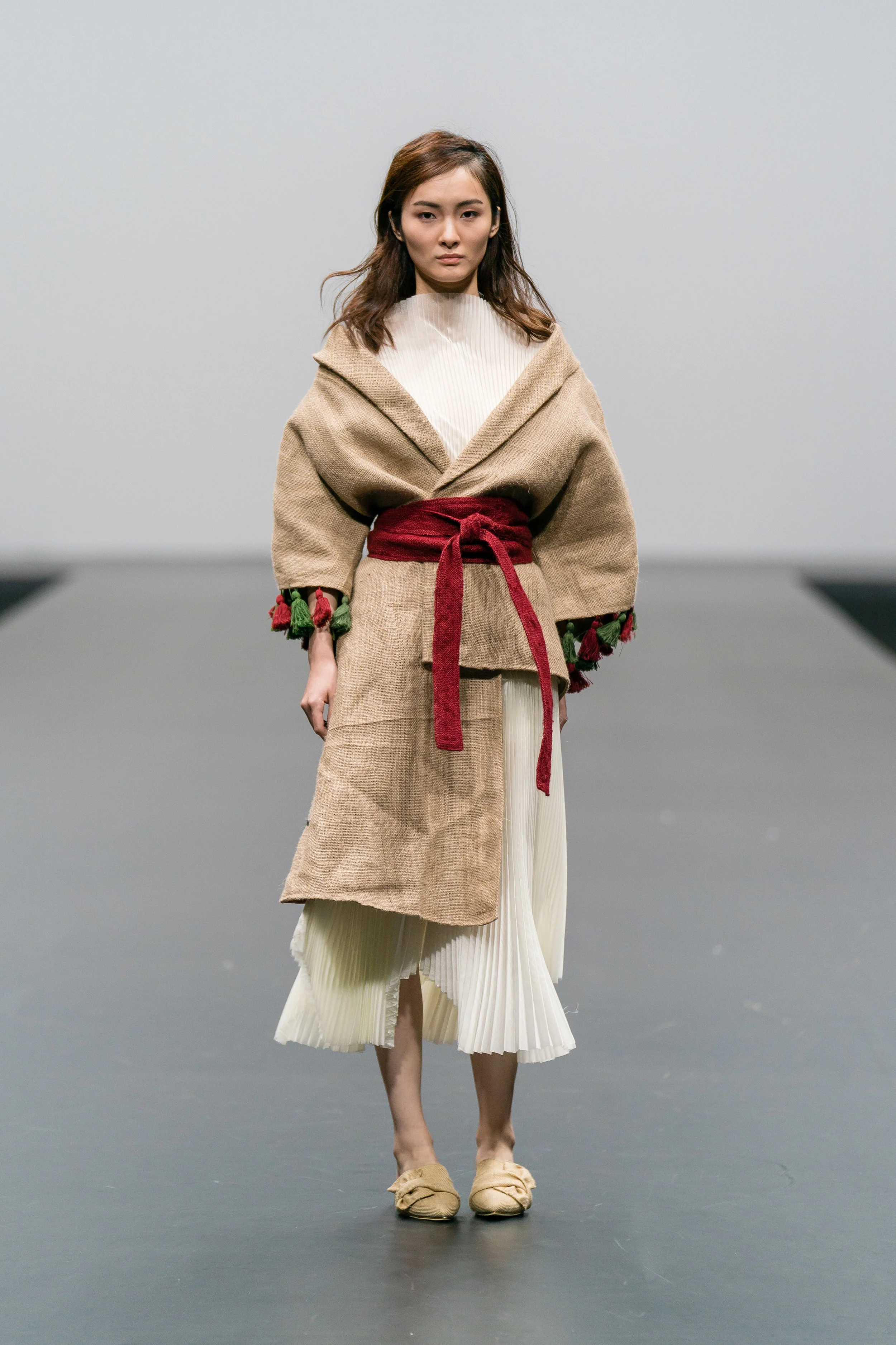 Sarah Devina Susanto Up-cycled cream pleated boat neck dress made from end-of-rolls with asymmetric coat and obi belt made from jute sacks