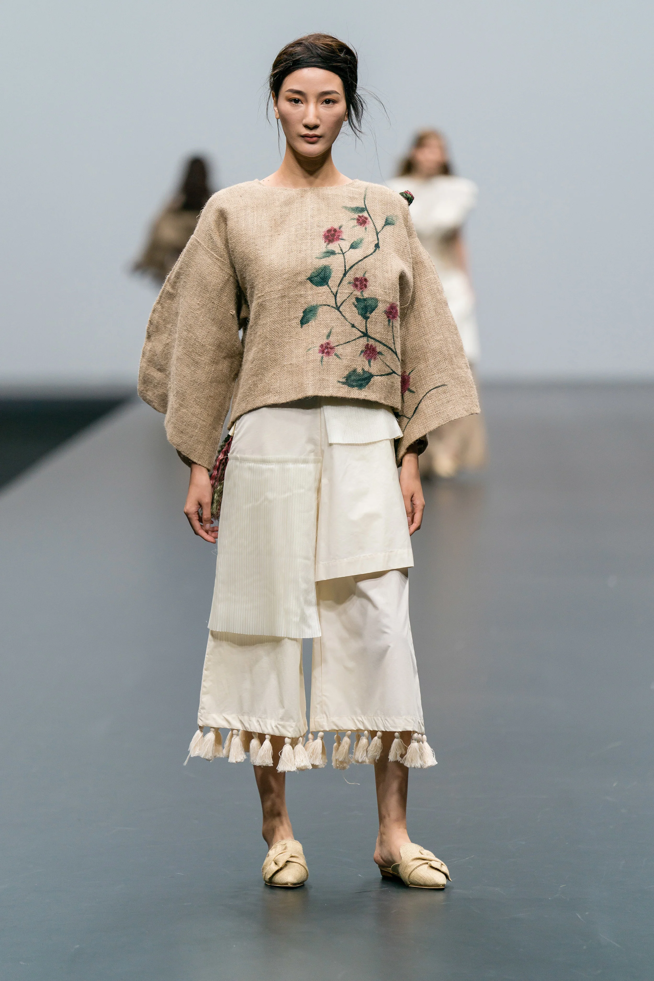 Sarah Devina Susanto Up-cycled hand-painted jute top and cream cropped trousers tassel detailing