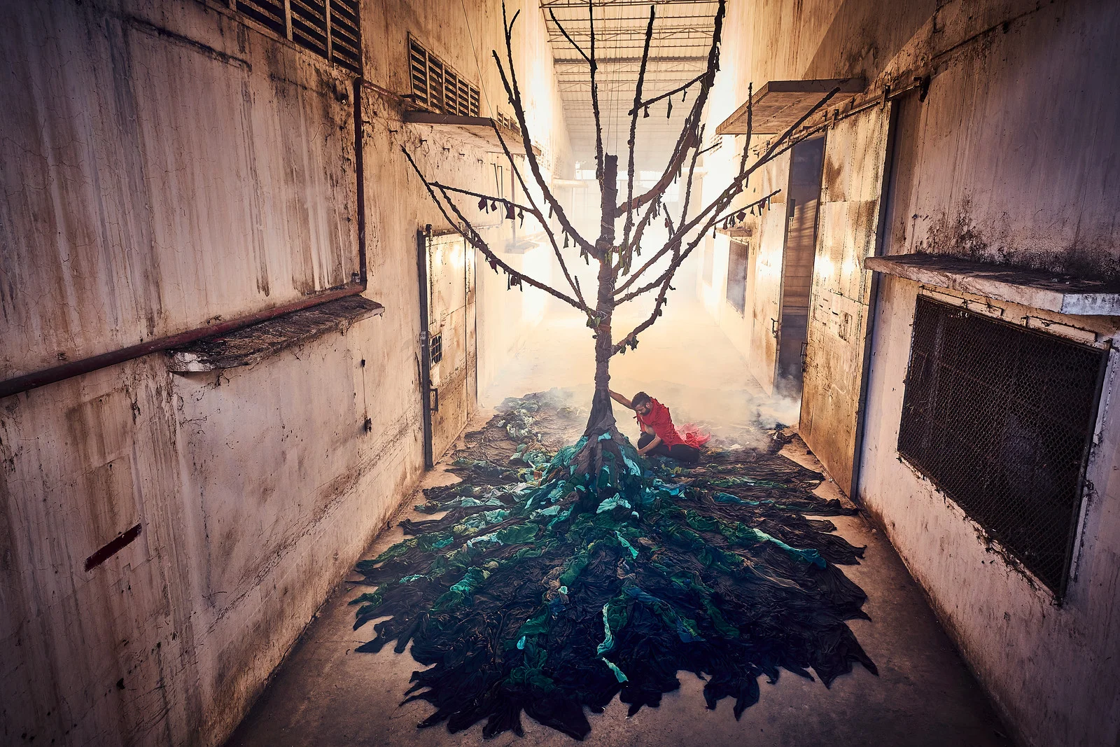 An abandoned garment factory in Phnom Penh is reclaimed by artists in a haunting exhibition that depicts the impact of the fashion industry on the environment. Photo credit Von Wong & Laura Francois, Clothing the Loop