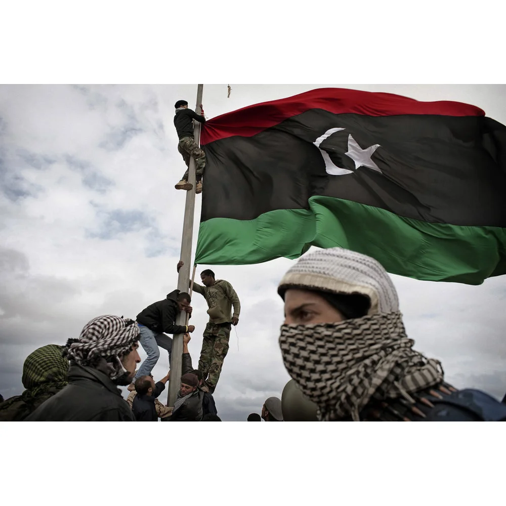 RAS LANUF, LIBYA - MARCH 08 2011: Libyan rebels raise their flag at a checkpoint in Ras Lanuf
 RAS LANUF, LIBYA - MARCH 08: Libyan rebels raise their flag at a checkpoint in Ras Lanuf