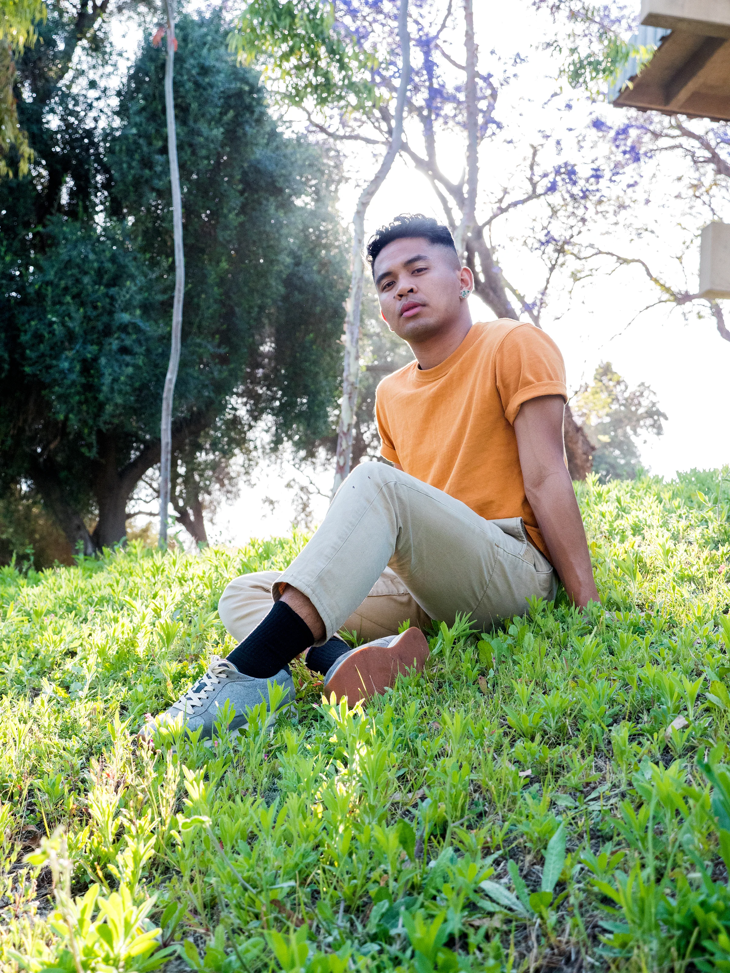 Navor poses for a photograph on the grassy hillside of Barnsdall Park in East Hollywood, CA June 4, 2018. Navor's artwork highlights the realities of living with disabilities, and the intersections of living as a queer and trans migrant of color. You can follow them on Instagram, @gnawvo r. Photo by: Eve Moreno-Luz
