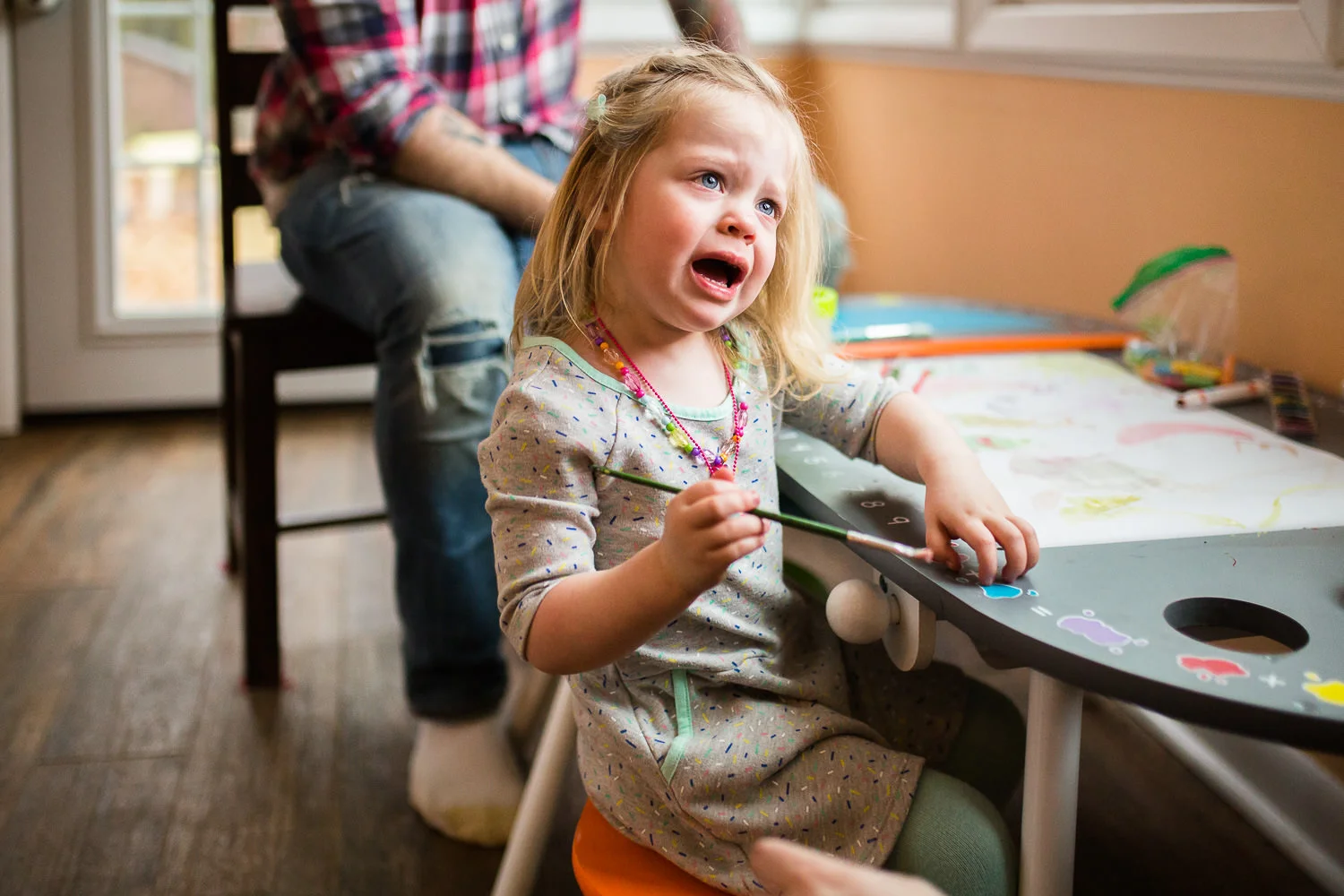 candid photo of toddler looking upset at parent