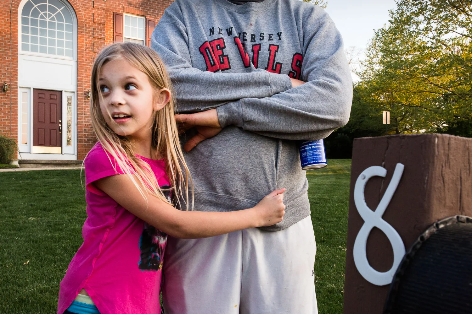 girl hugging her father in front of her house