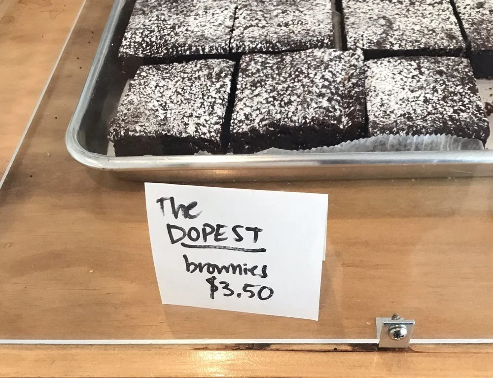 Our old pastry case (until March 2018) was plexiglass screwed into the plywood countertops. We sharpied signs onto cardstock. We used our beat-up baking trays for display. I continue to cringe at this. (Photo by Yelper Kathy Z. from September 2017.)