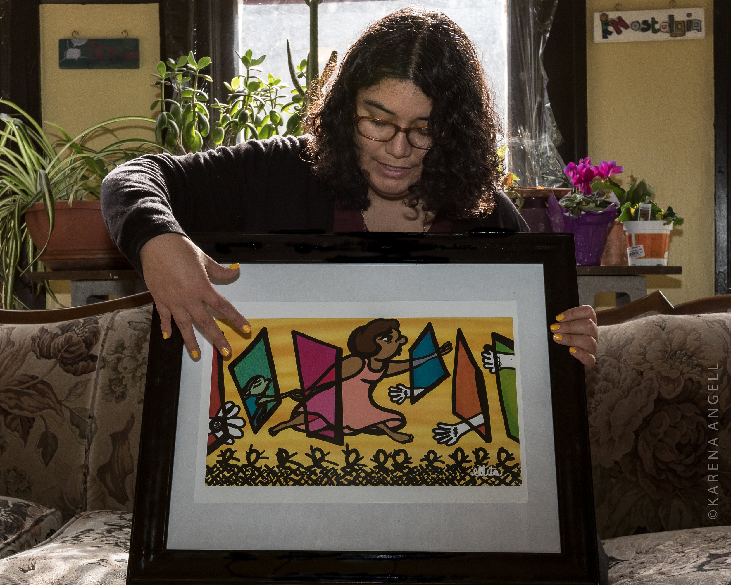 Ella Mendoza holds her artwork, "Cruzando Fronteras" or "Border Crossing". (Photo by Karena Angell)