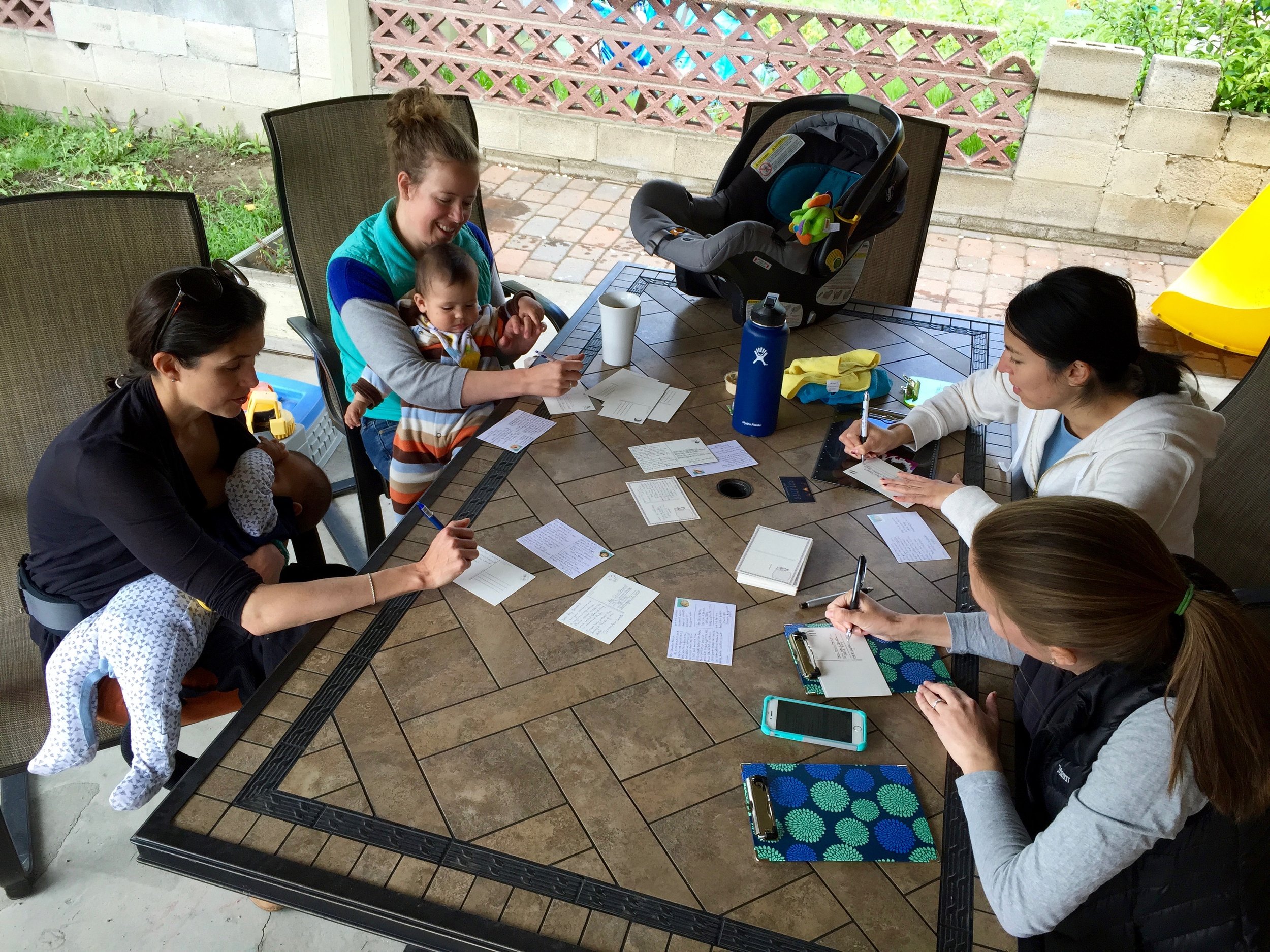Claire Trapp, Jessica Arce-Larreta, Silvia Catten, and Brienne Henderson write postcards to their representatives in Millcreek, UT. (Andrea Smardon)
