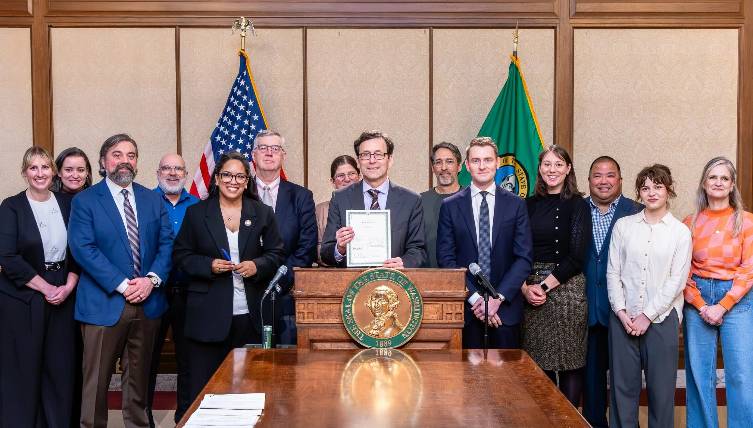 Photo of Washington State Non-profit leaders and Gov. Bob Ferguson at signing of EHB 2211