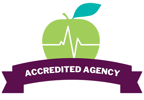 Logo to recognize us as an Accredited Agency: Food is Medicine Coalition, logo is a green apple with a purple banner with white text