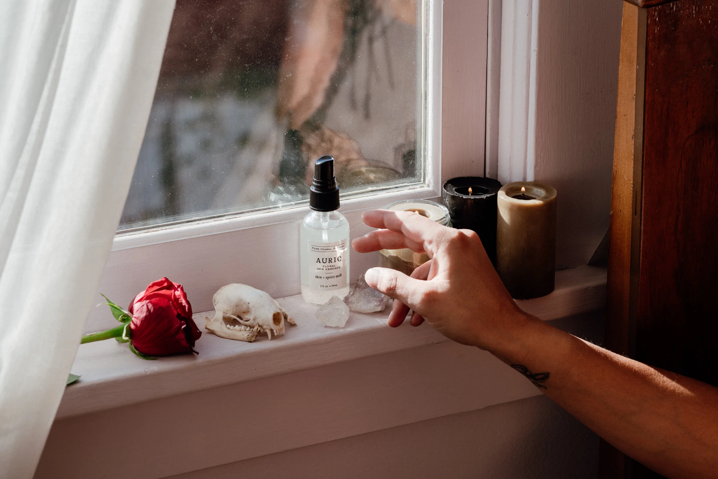 woman reaching for Kore Herbals AURIC- Rose + Frankincense skin + spirit mist