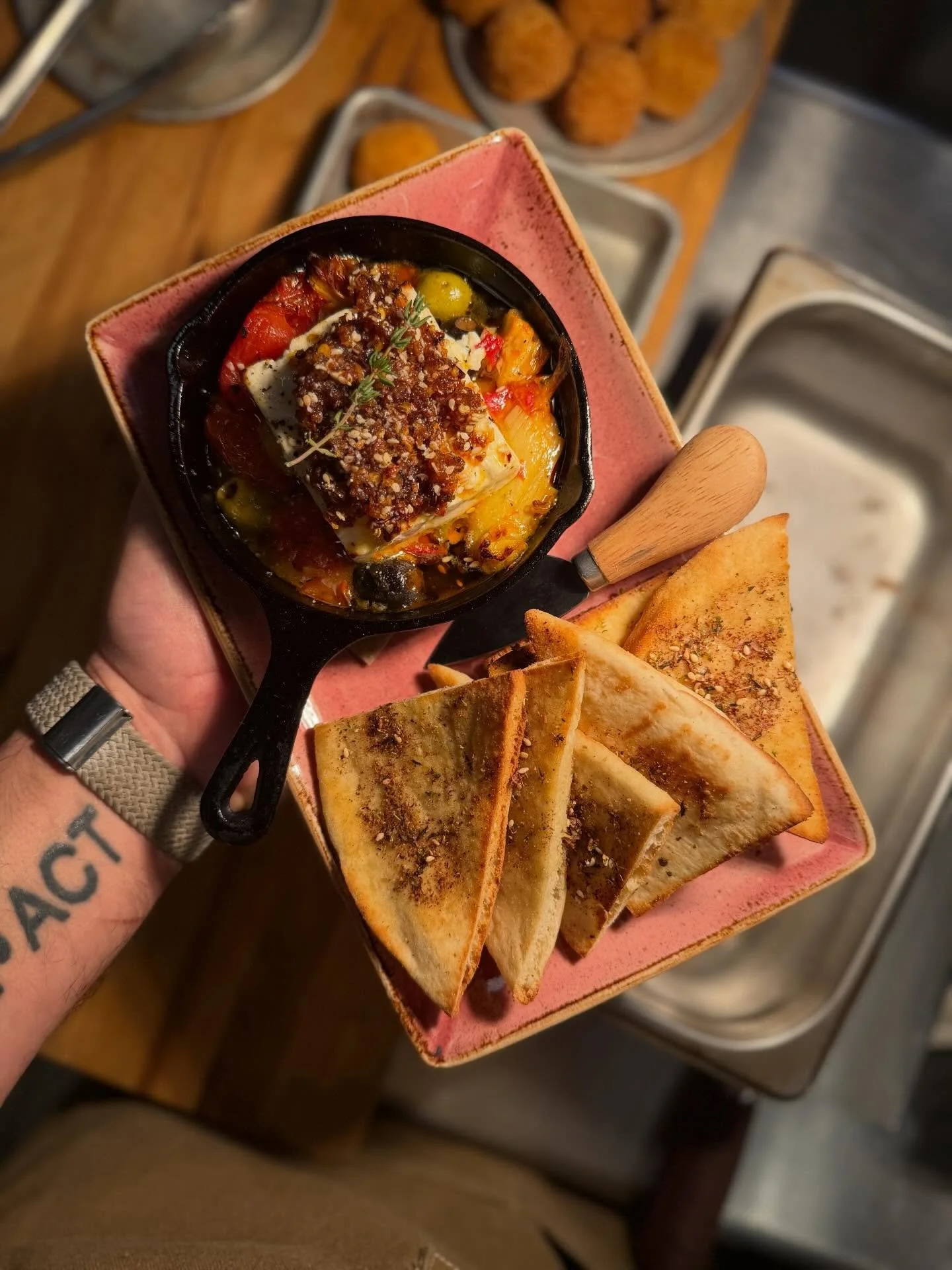 Baked Feta, straight from the heart of the menu 🔥
Warm feta baked with tomatoes and olives, finished with chili crisp and herbs&mdash;rich, savory, a little spicy, and absolutely meant to be scooped up with warm pita. One of those plates that disapp