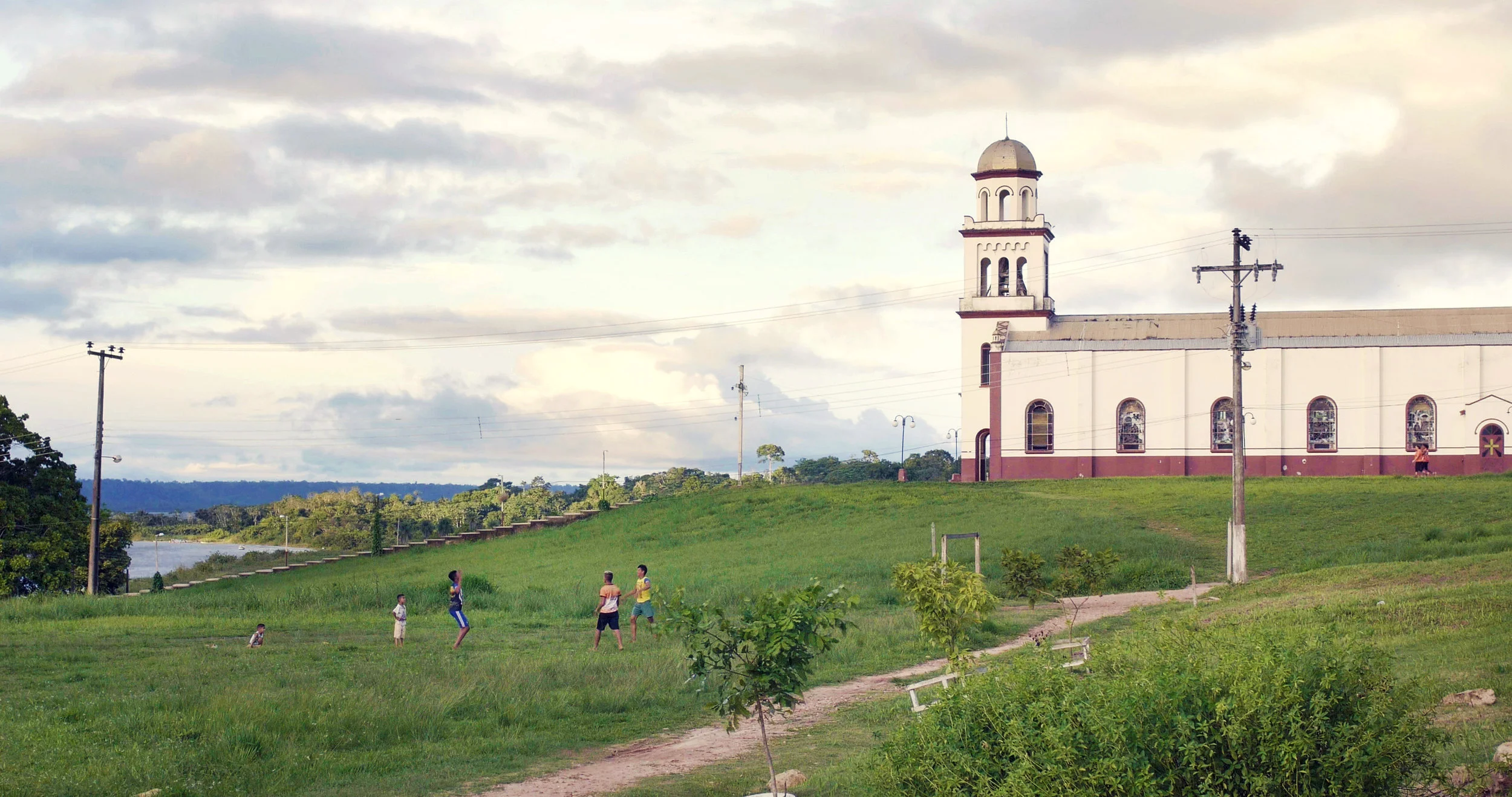 Kids playing football by the church.
