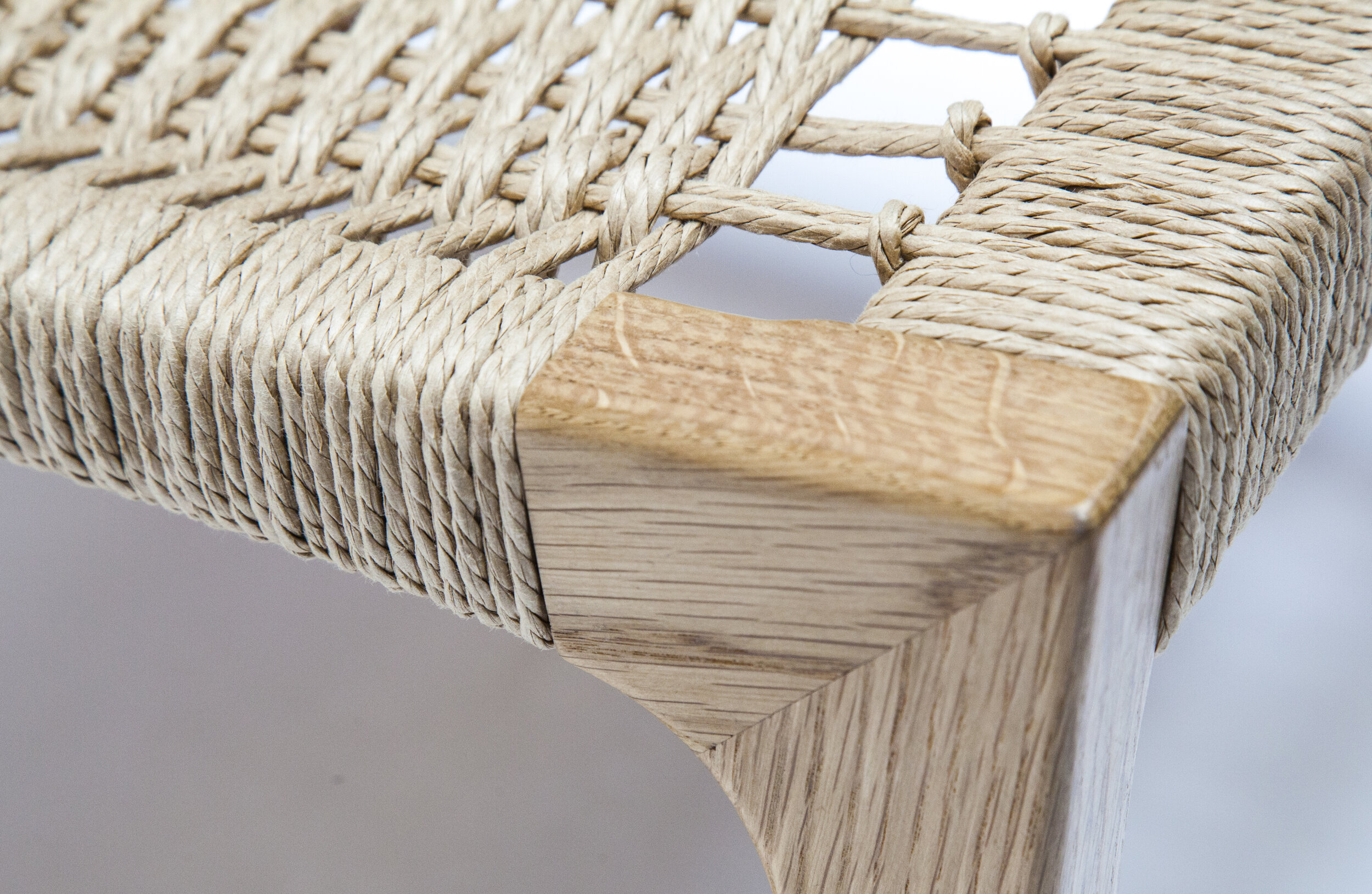 Close-up of a front leg showing precision joinery and woven wrap.