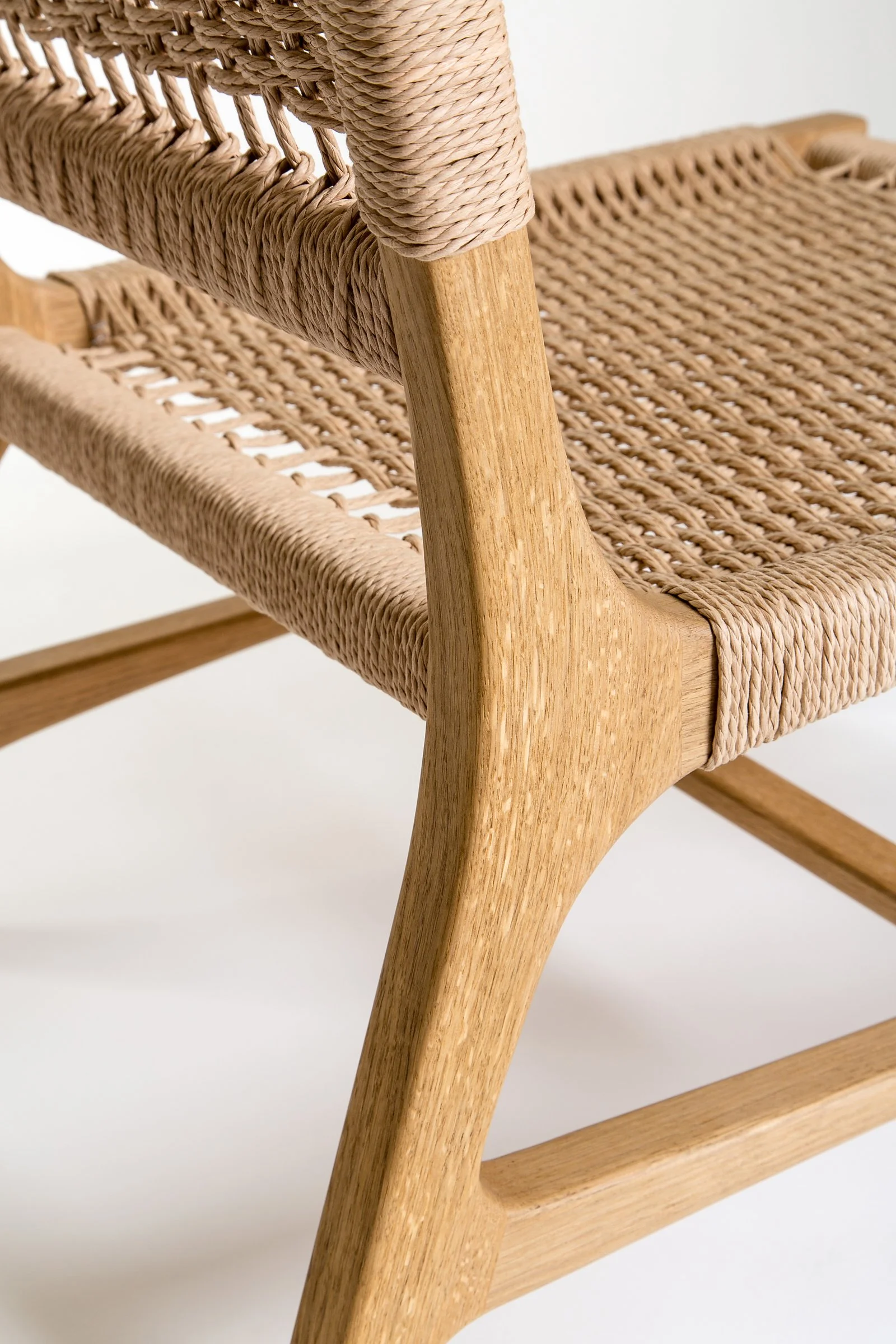 Detail of the rear leg's elegant curve and seamless connection to the backrest.