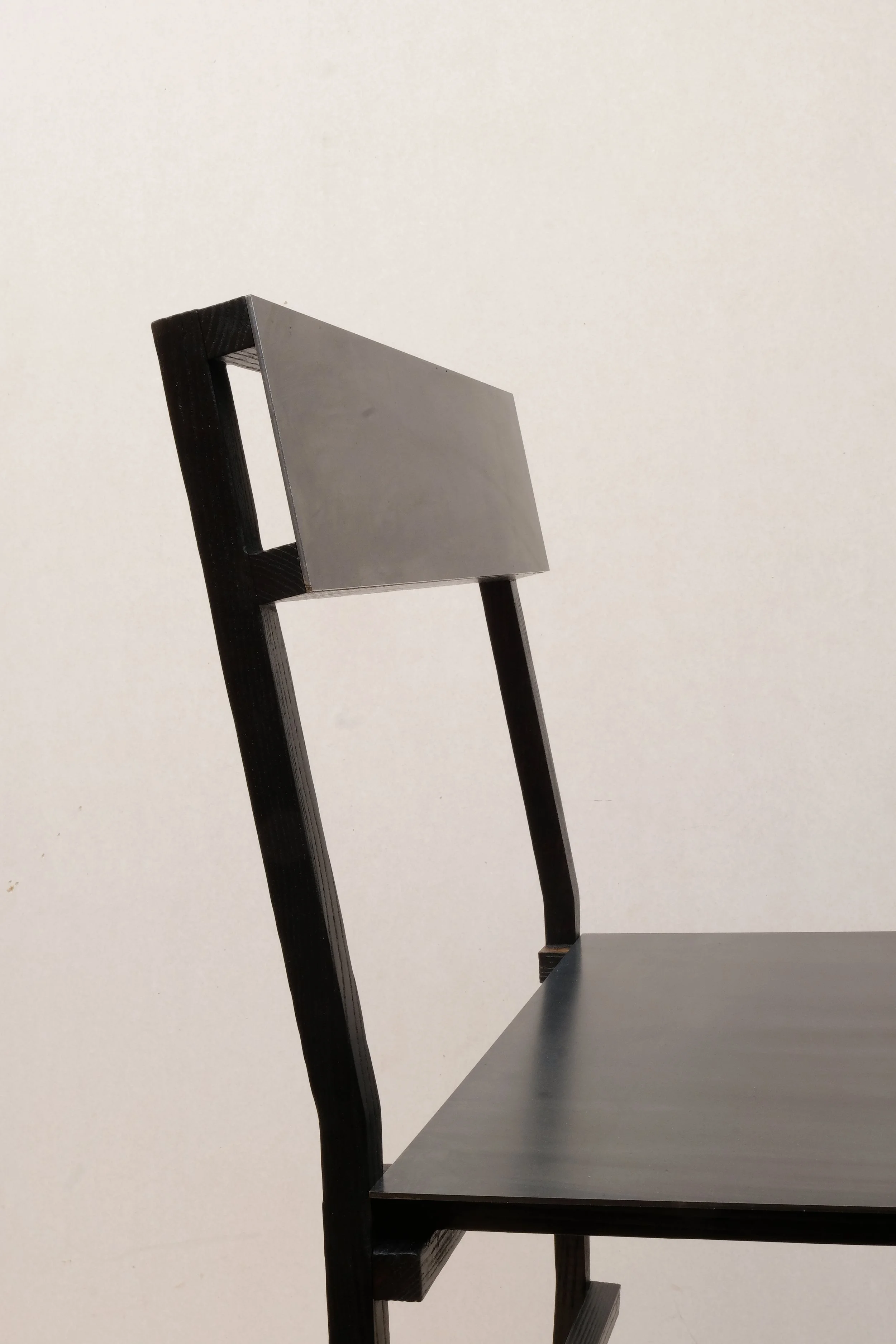 Detail of the chair’s backrest showing its simple rectangular shape and clean joinery.