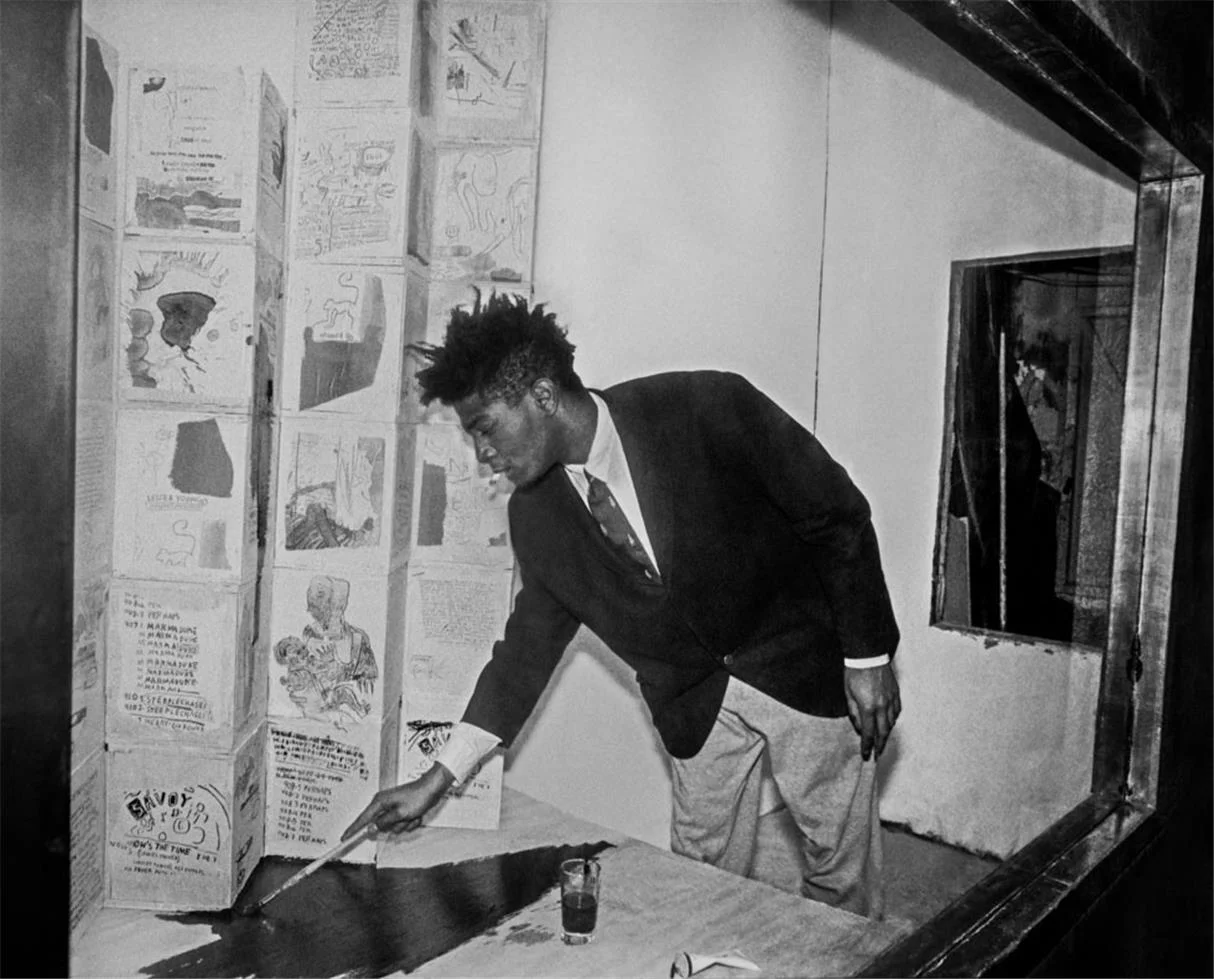 Basquiat retocando uma vitrine com obras em 1985
