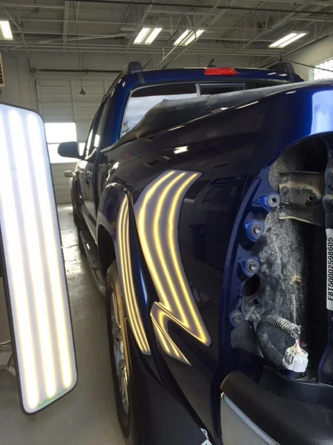 Blue truck panel after paintless dent repair
