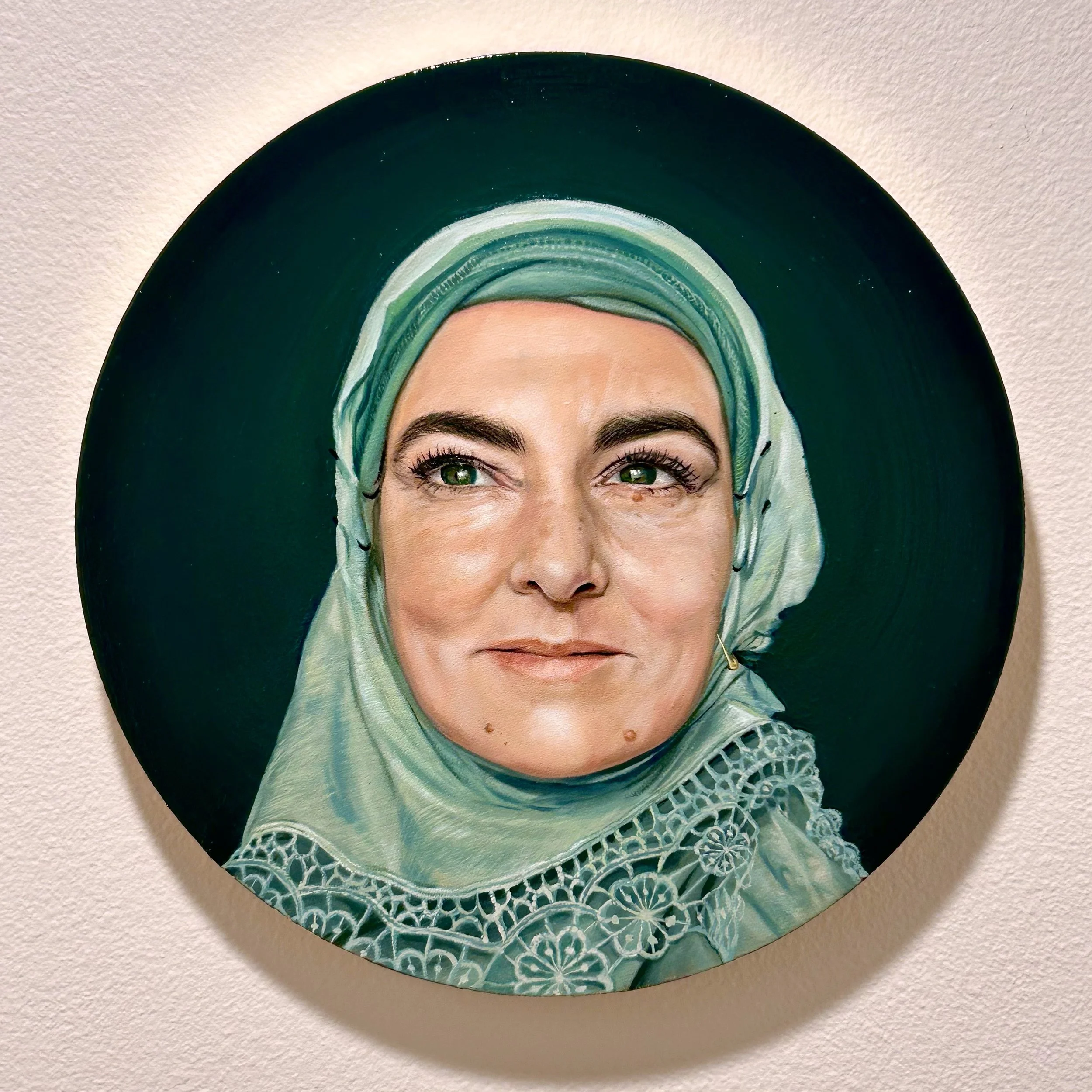 A portrait oil painting of Sinéad O'Connor in a mint green headscarf with a dark green background.