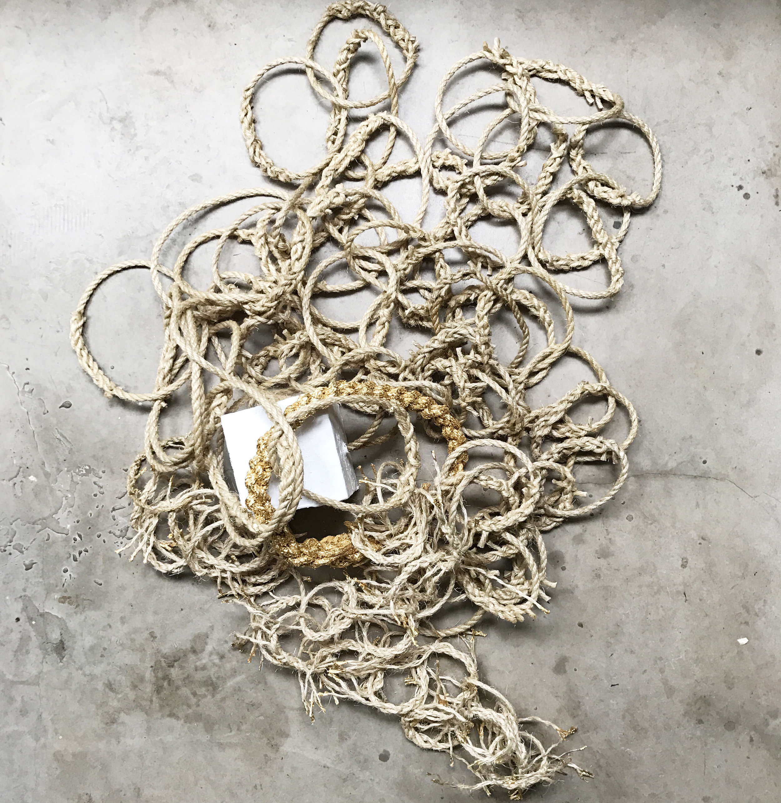 Somewhen , inspired by Gunter's Chain, a tool designed in 1620 to survey and plot land. 100 sisal rope links, plaster and metal leaf (2017)