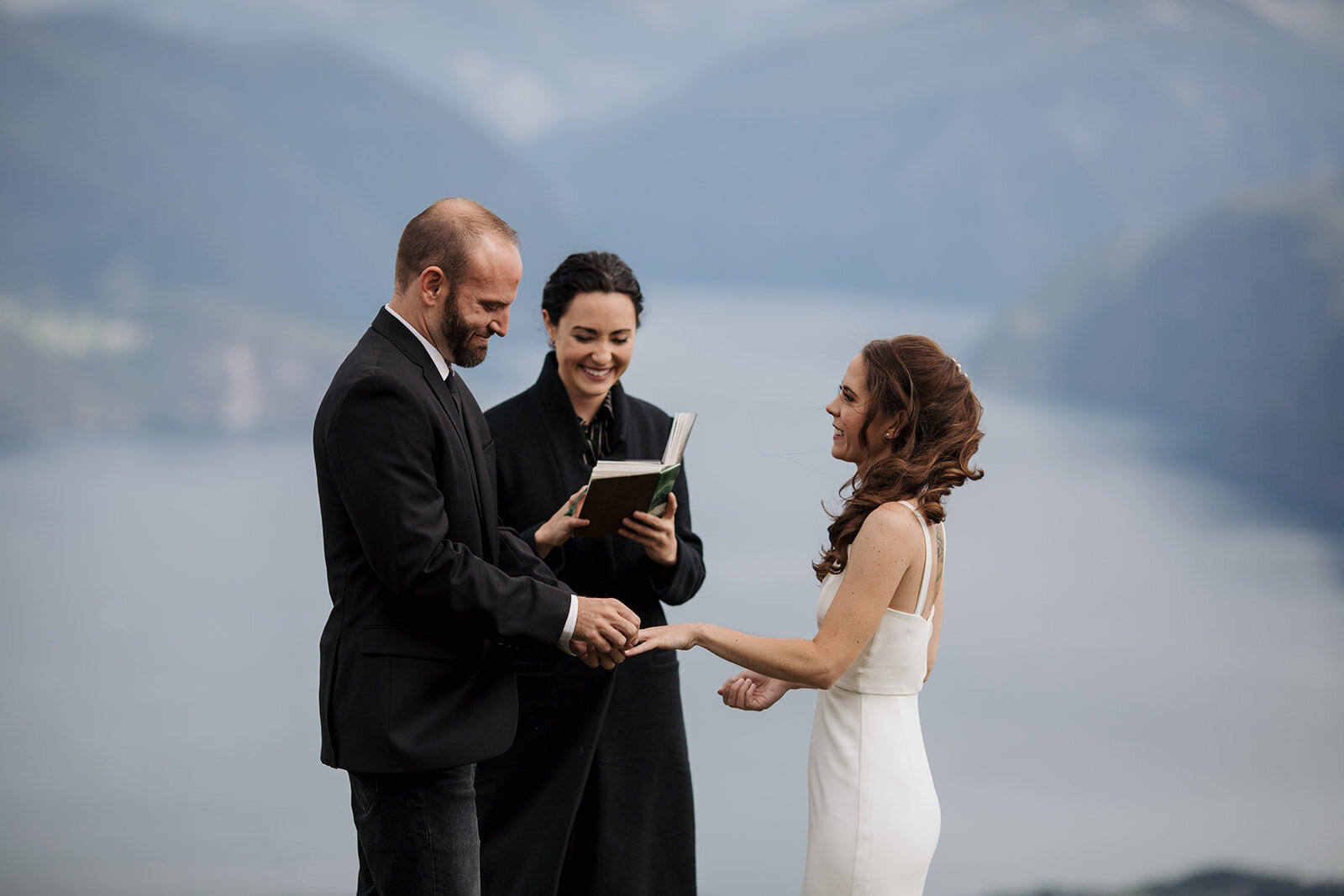 Bride and groom exchange rings during their elopement by Promise Mountain