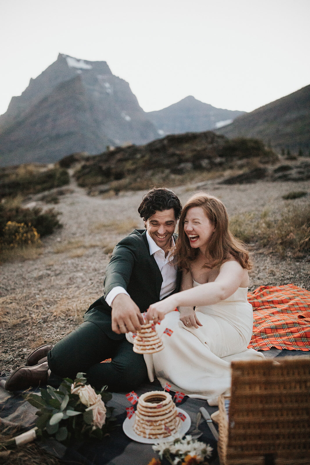 Bride and groom sharing a laugh with each other while having a picnic at their Montana elopement