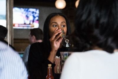 Creator of the food blog "Just Add Hot Sauce," Alex Hill, drinking a glass of wine.