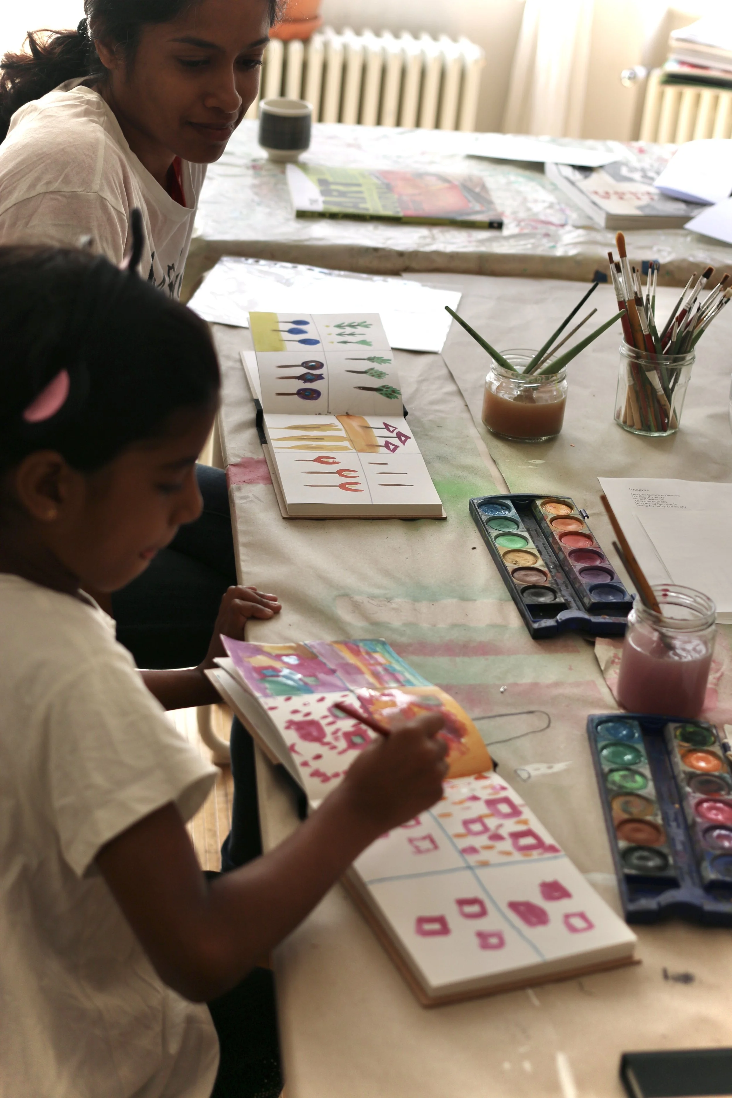 Child freely exploring watercolour in their journal